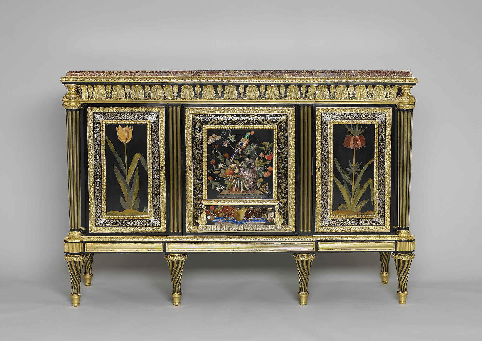Rectangular cabinet veneered with ebony and set with three pietra dura panels of flowers and birds, the central panel incorporating high relief pietra dura fruit; bordered with premiere partie boulle marquetry on tortoiseshell. Fitted with three doors con