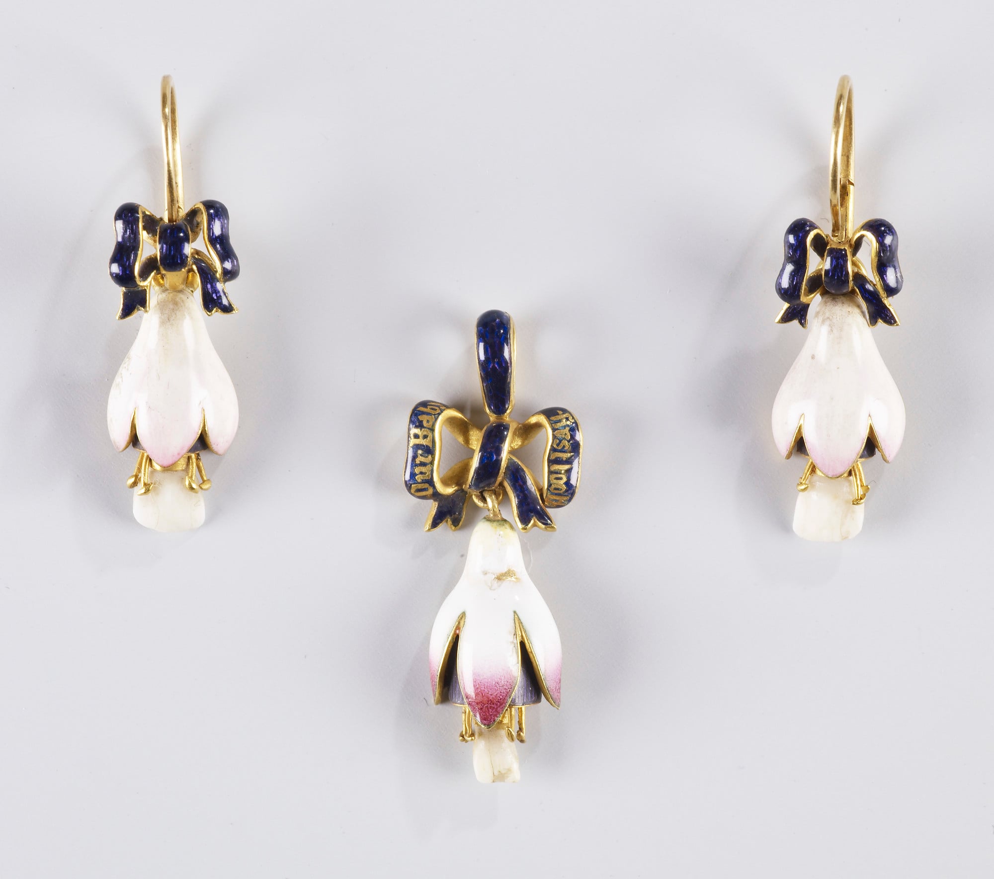 Pendant and earrings in the form of fuscias A pendant and a pair of gold mounted enamel earrings in the form of a fuscia flower set with milk teeth from Princess Beatrice (1857-1944), Queen Victoria's youngest child. These are suspended from an enamelled ribbon.
The work of setting the teeth in the