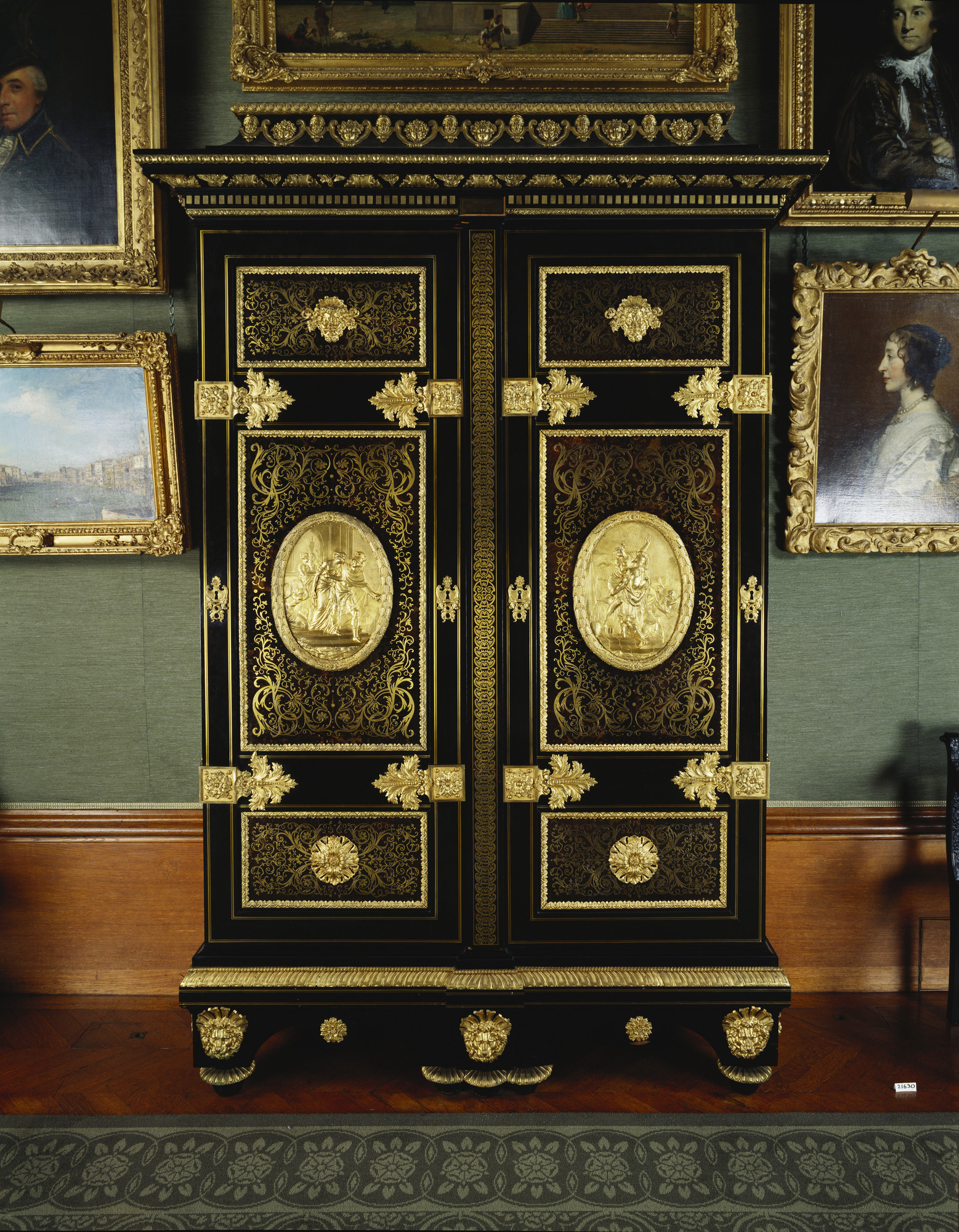 Tall rectangular armoire, inlaid with tortoiseshell and brass boullework, with gilt bronze mounts. Two panelled doors, each in three sections; the upper sections centred with gilt bronze masks, the lower sections with gilt bronze rosettes and the central 
