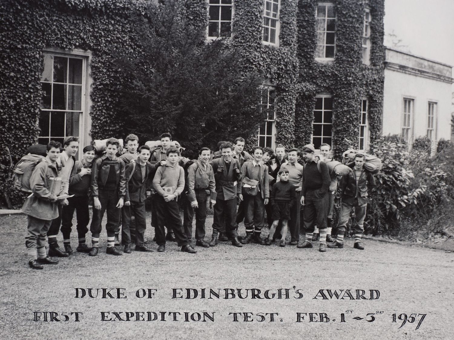 Photograph of a group of young boys with rucksacks and outdoor clothing pictured standing outside an ivy clad building who took part in the Duke of Edinburgh's Award First Expedition
