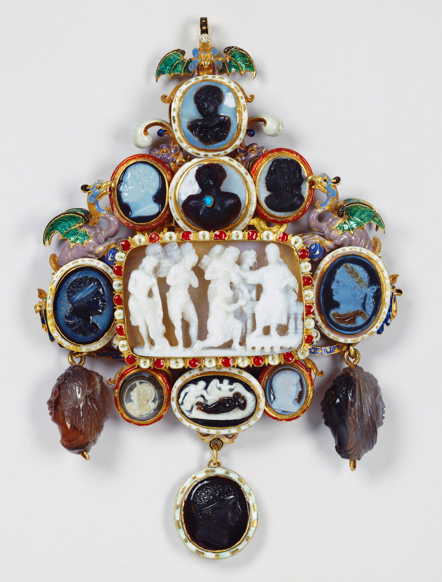 Pendant with thirteen cameos Gold openwork pendant with opaque white and middle-blue enamel foliate scrolls and two dragons on cornucopiae in opaque mauve, translucent green and opaque pale-blue émail en ronde bosse on either side of a central arched niche. The jewel is surmou