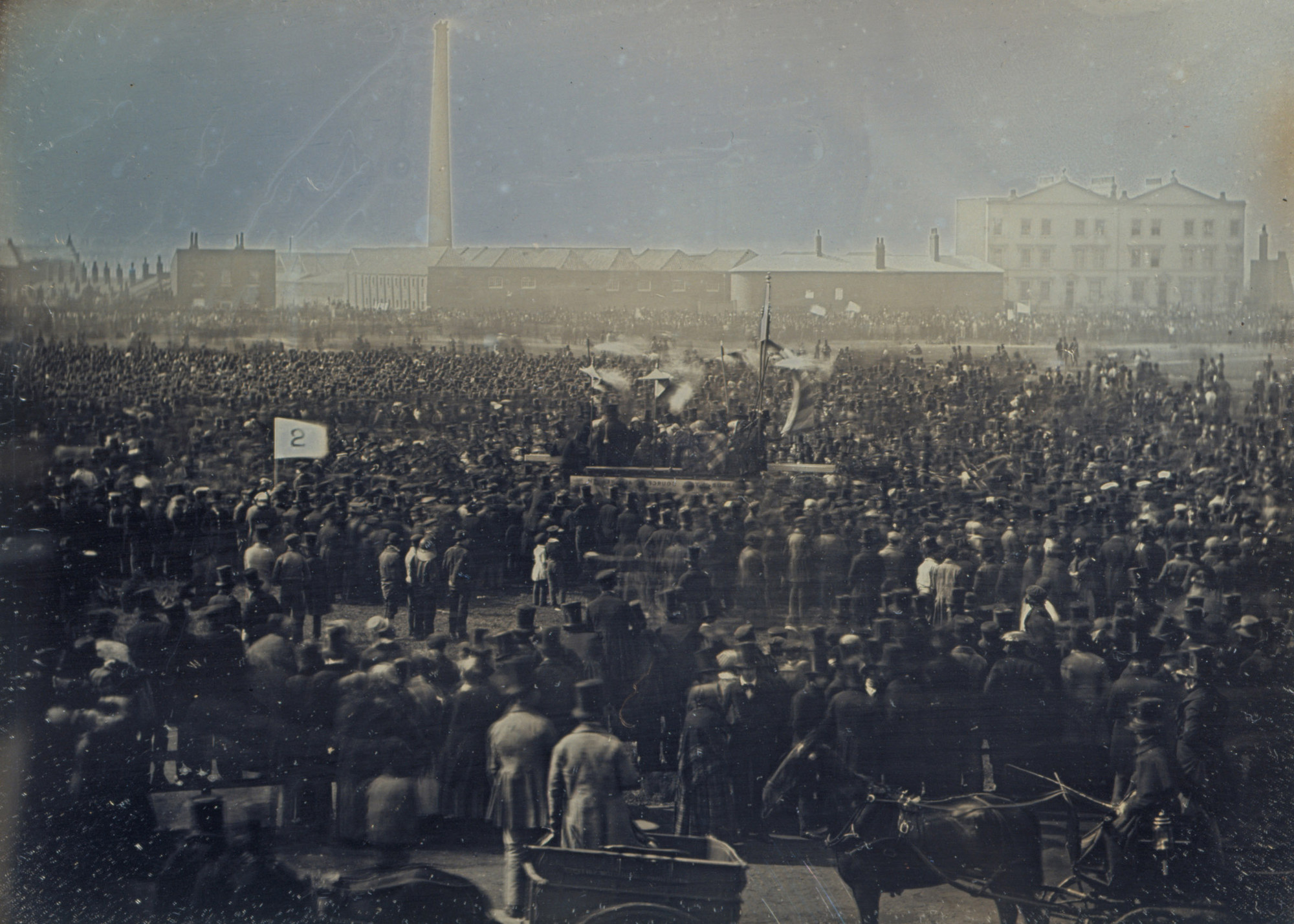 The Chartist Meeting on Kennington Common, 10 April 1848 Daguerreotype of a large crowd of supporters of the Chartist movement gathered together on Kennington Common. At the centre of the crowd there is a platform for the speakers, and a number of people hold banners and flags. Behind the crowd there is a tall