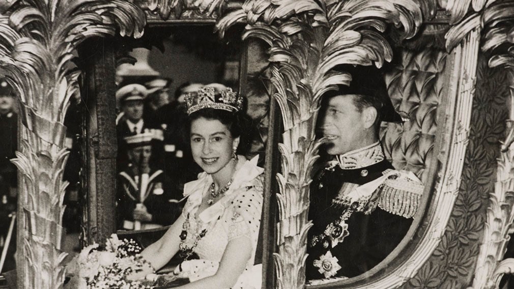 HM Queen Elizabeth II and HRH The Prince Philip, Duke of Edinburgh, en route to the Coronation of Her Majesty, 2 June 1953 Photograph of HM Queen Elizabeth II sitting beside HRH The Prince Philip, Duke of Edinburgh in the Gold State Coach on their way to Westminster Abbey for the Coronation Service. In the background can be seen Naval Officers with rifles and Police