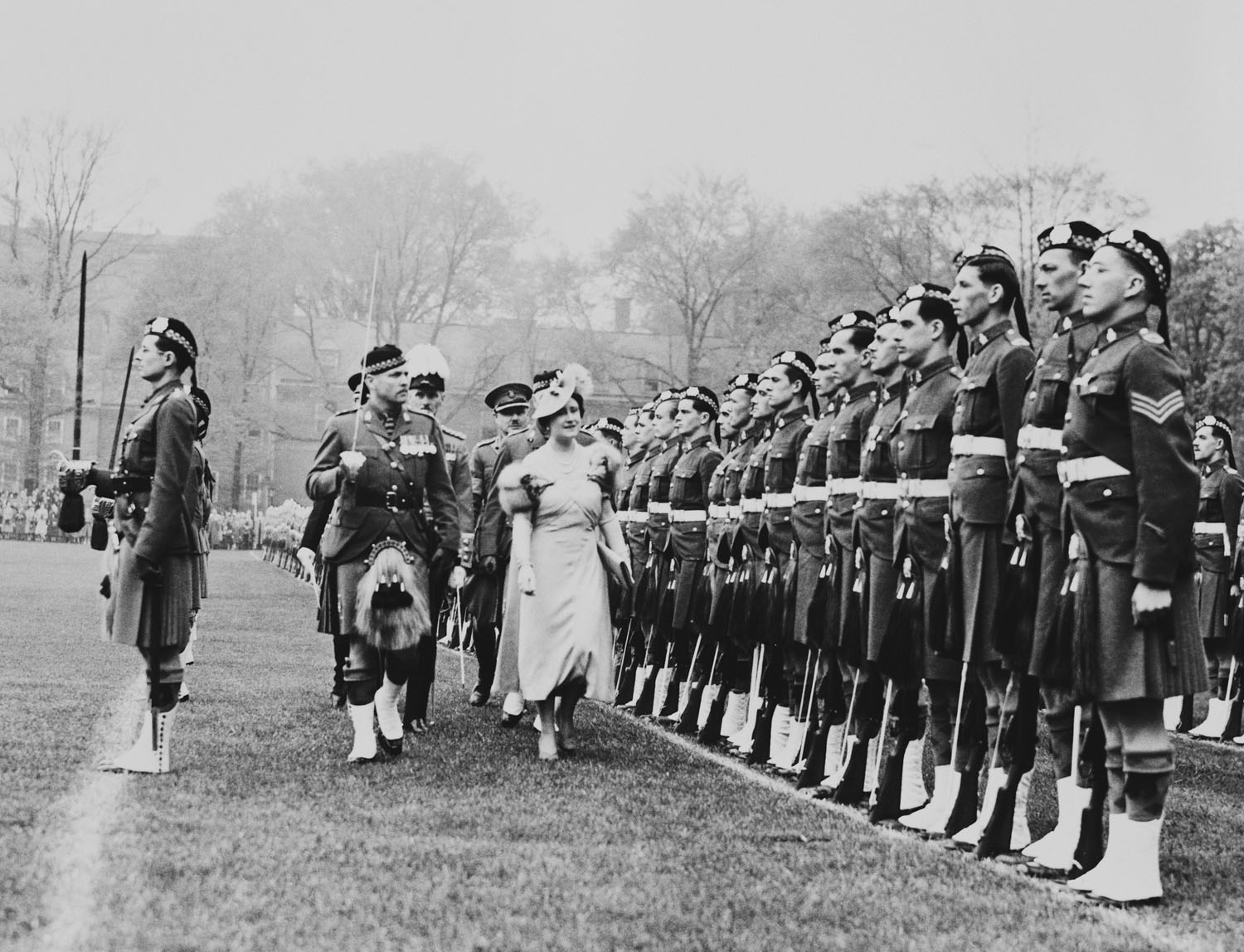Queen Elizabeth inspecting the Toronto Scots Regiment on the north campus of Toronto University Photograph of Queen Elizabeth (1900-2002), later Queen Elizabeth the Queen Mother, inspecting the Toronto Scots Regiment on the north campus of Toronto University, where she presented Colours to the Regiment