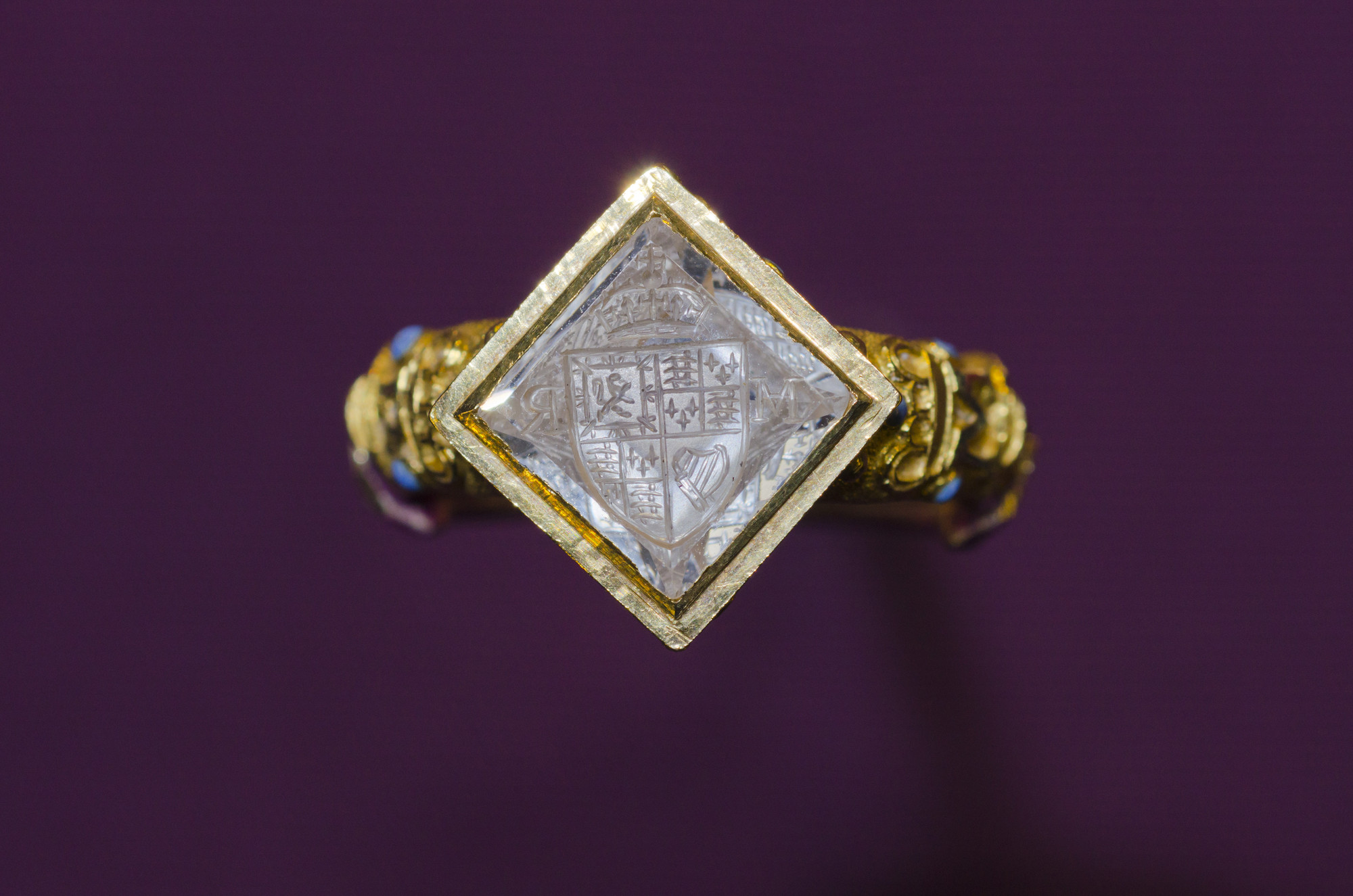 Signet ring Gold signet ring, the shoulders cast and enamelled with crowns above an HMR monogram. The ring is decorated with enamelled rose, thistle and fleurs-de-lys. The top is set with a lozenge-shaped diamond, carved with an intaglio crown, Royal coat of arms and