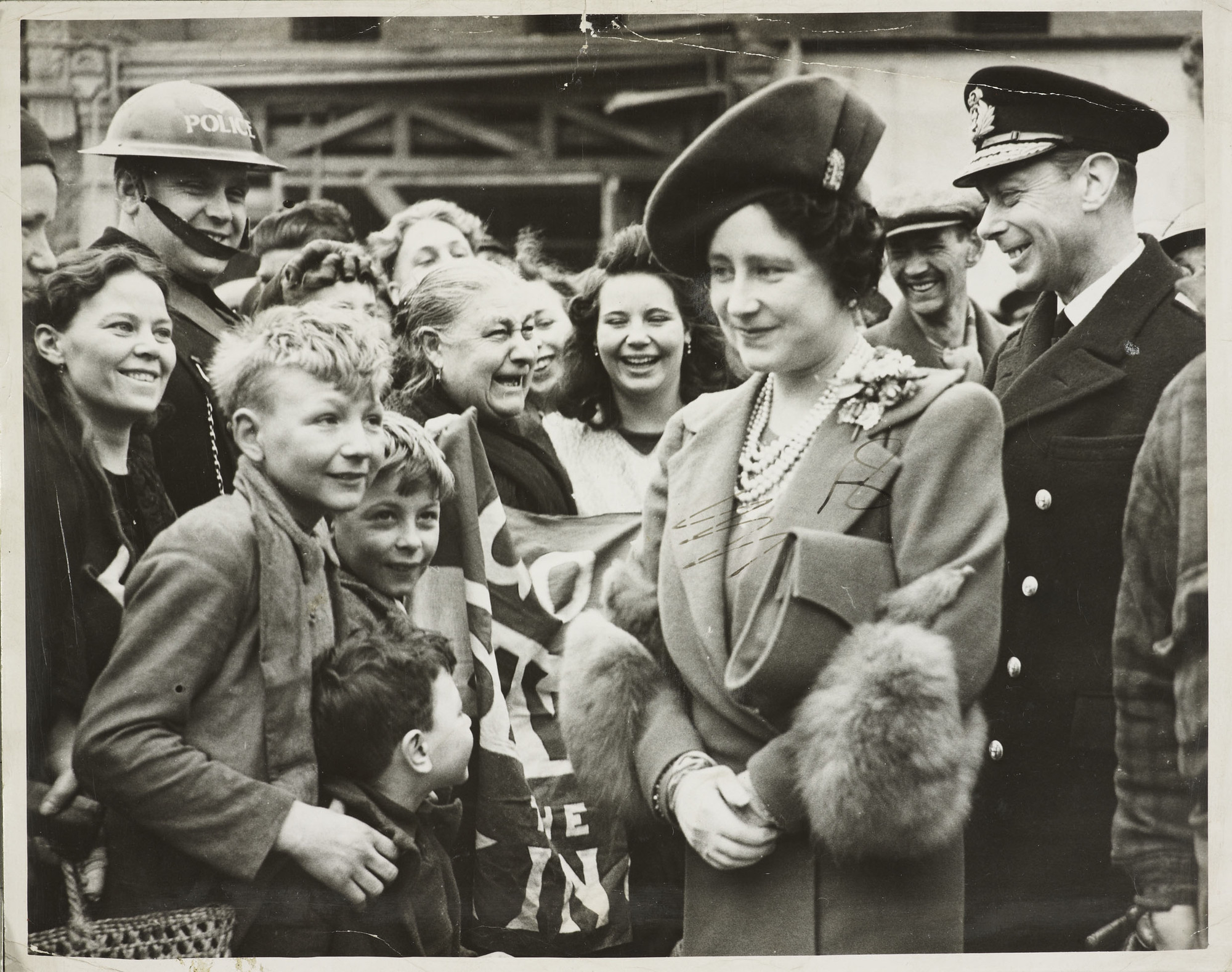 King George VI (1895-1952). George VI and Queen Elizabeth meet women and children of bomb damaged areas of the East End of London.