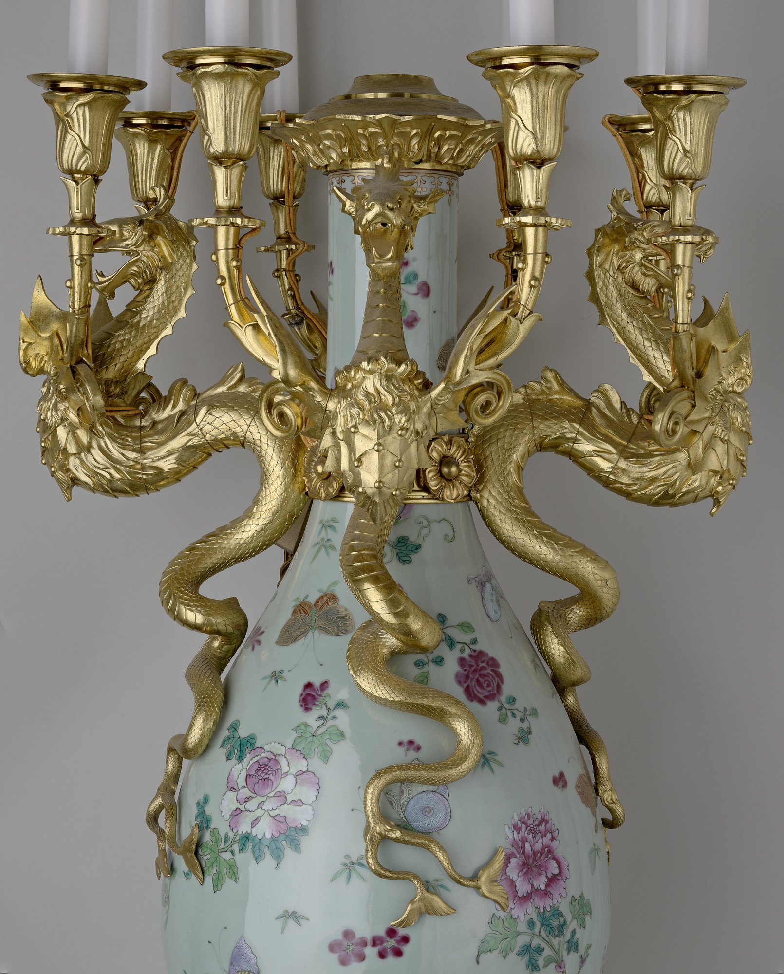 Pair of bottle vases mounted as eight-light candelabra Eight-light candelabra consisting of a Chinese porcelain vase fitted with English gilt-bronze mounts. Pear-shaped, the tall necks cut down and side handles apparently removed. The celadon glaze overpainted with flower sprays and butterflies, with a r