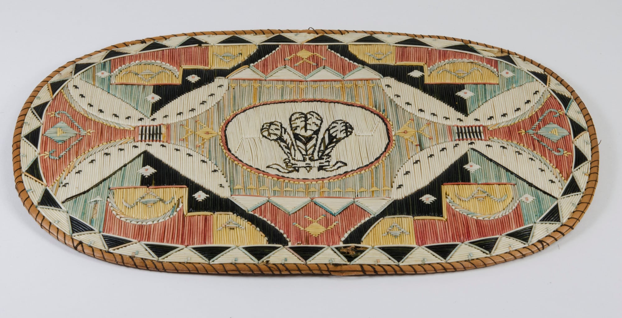 Mat Mi'kmaq oval birch-bark mat solidly quilled with porcupine quills, backed with birch bark and sewn together with spruceroot thread, with central panel of the Prince of Wales feathers; part of a set of fourteen mats and a quilled container