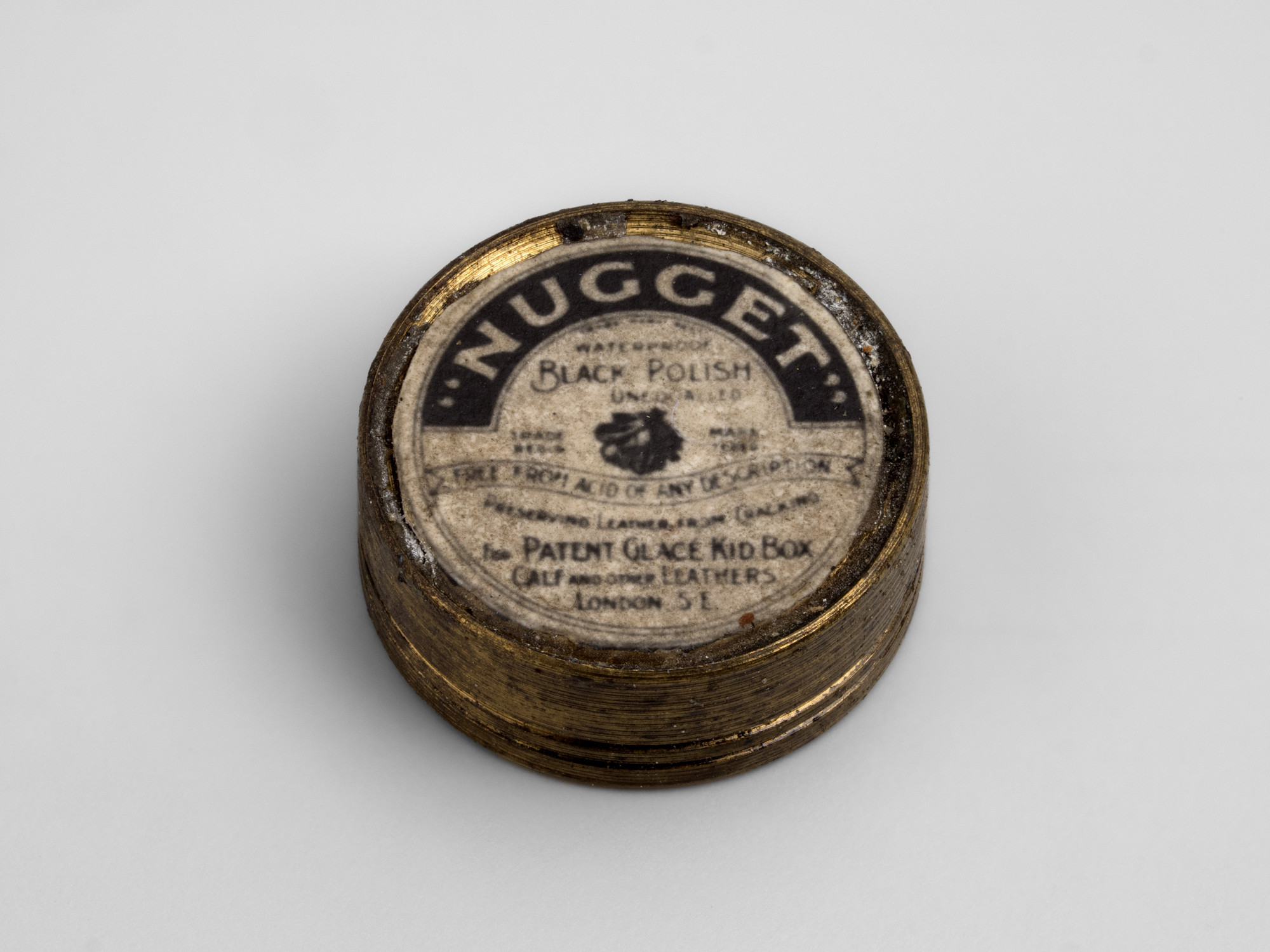 Miniature circular tin of Nugget leather polish; label on lid