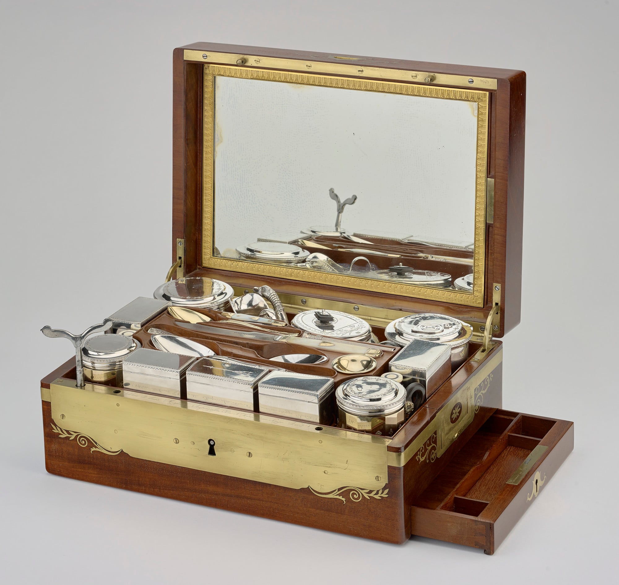 Travelling service (RCIN 43936) A silver and silver-gilt travelling service in a mahogany and brass-bound box, the lid inset with a brass shield engraved with the SN monogram of Stéphanie Napoleon (Stephanie de Beauharnais). The box has brass carrying handles and i