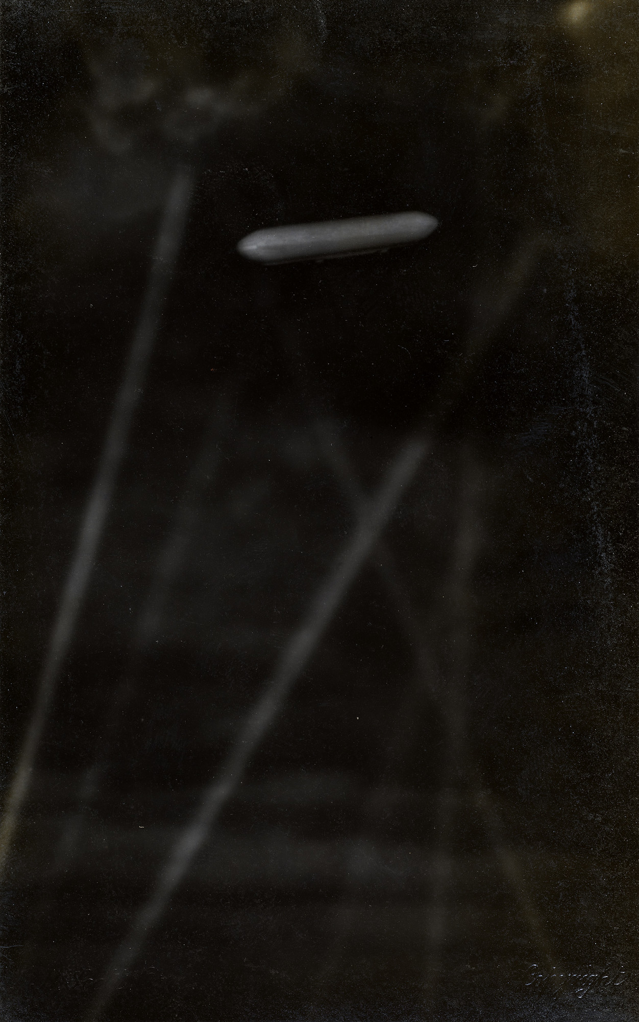 SL11 caught in the beams of searchlights Photograph of a Schütte-Lanz (SL-11) caught in beams of searchlights. The Schütte-Lanz appears luminous against the night sky.