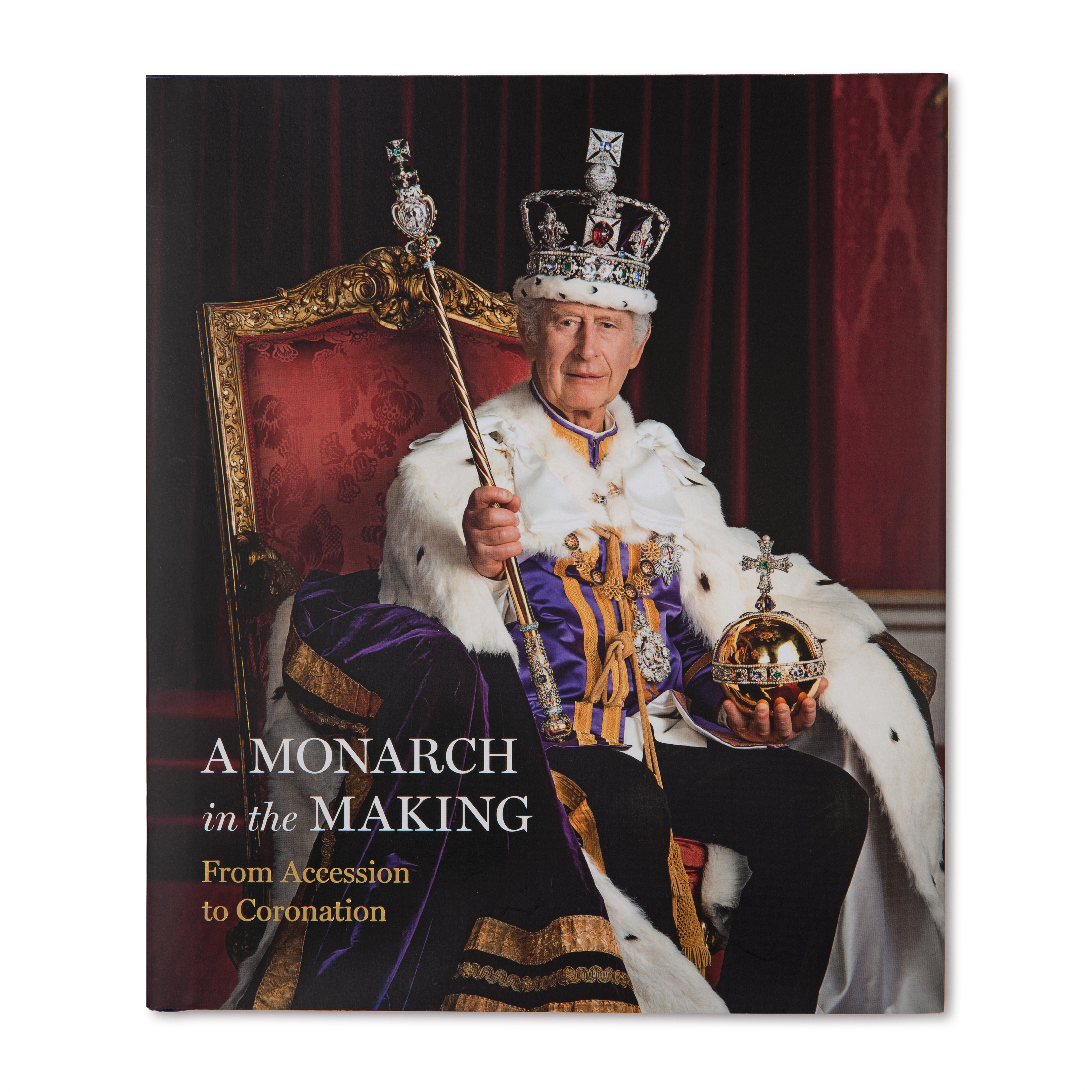 The front cover of the book 'A Monarch in the Making: From Accession to Coronation' featuring King Charles III on the throne
