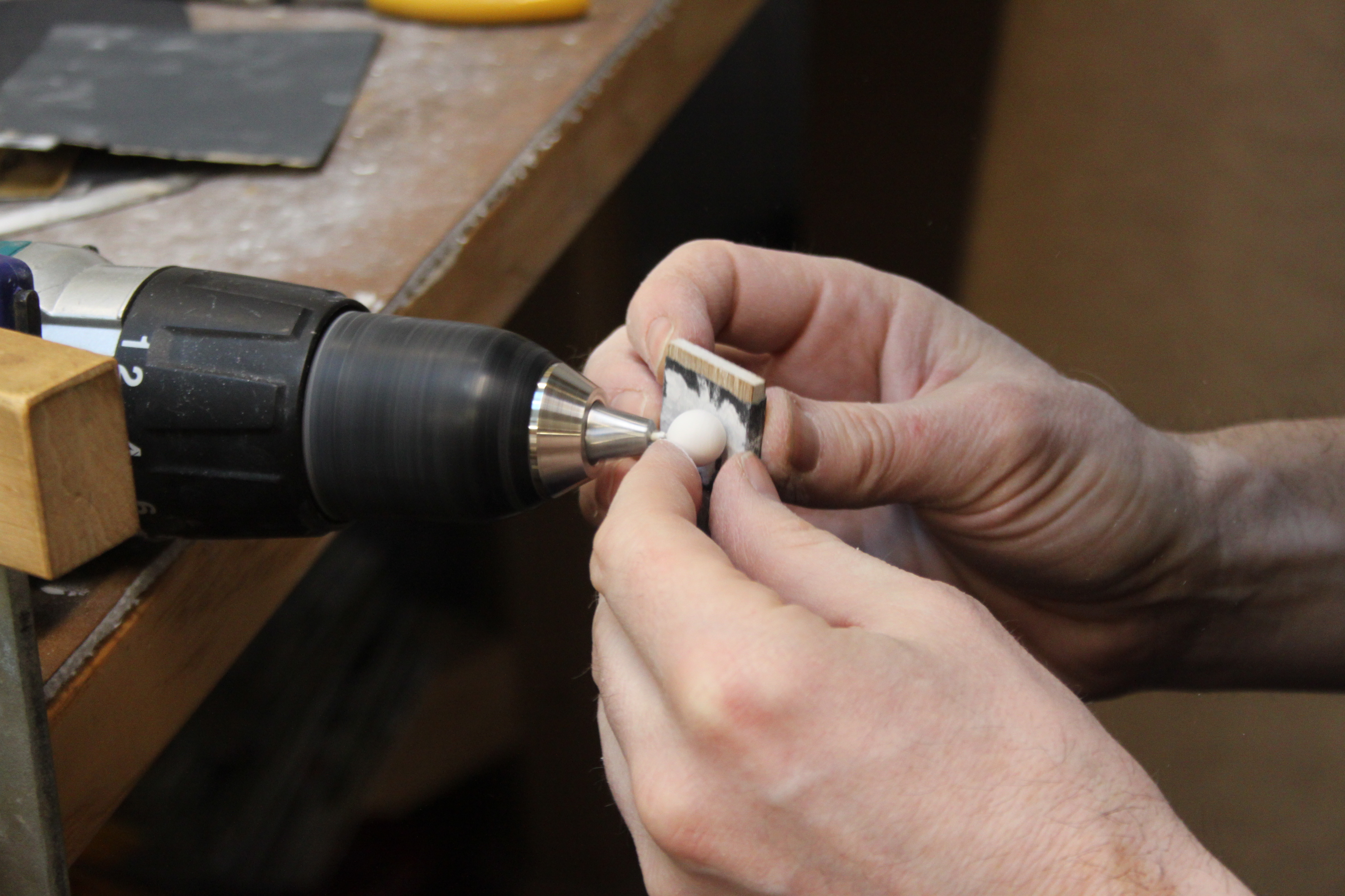 A ball being worked on at a sander to smooth the edges