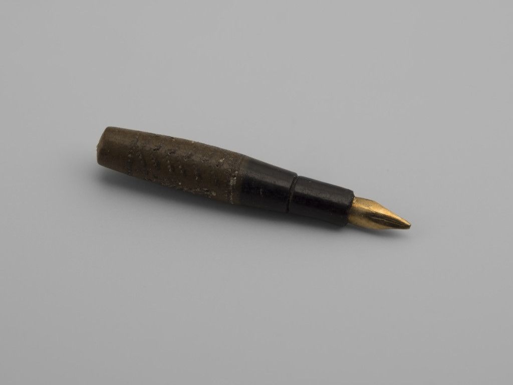 Miniature fountain pen of textured plastic with gilt metal nib.