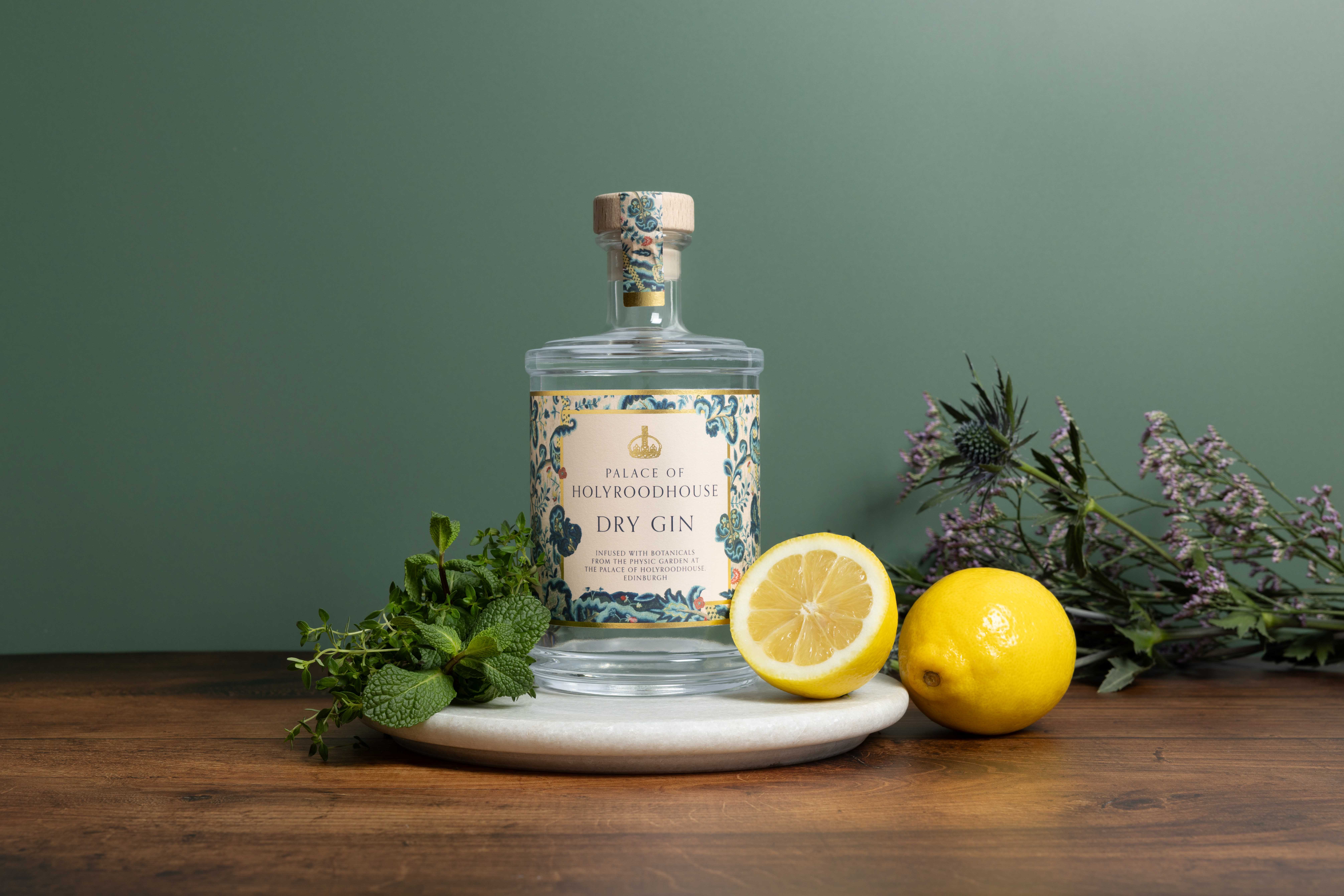 The Palace of Holyroodhouse Dry Gin Photograph of a bottle of the Palace of Holyroodhouse Dry Gin surrounded by fresh lemons and herbs