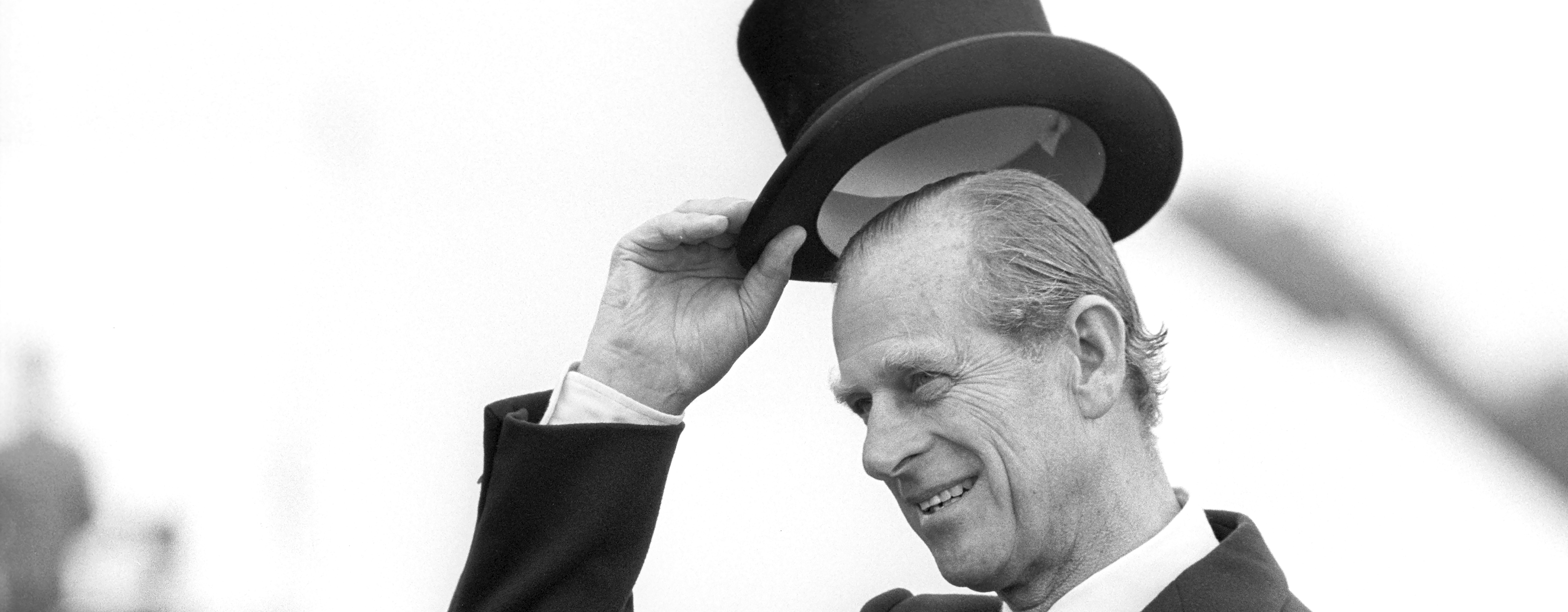 Prince Philip raises his top hat to acknowledge a crowd