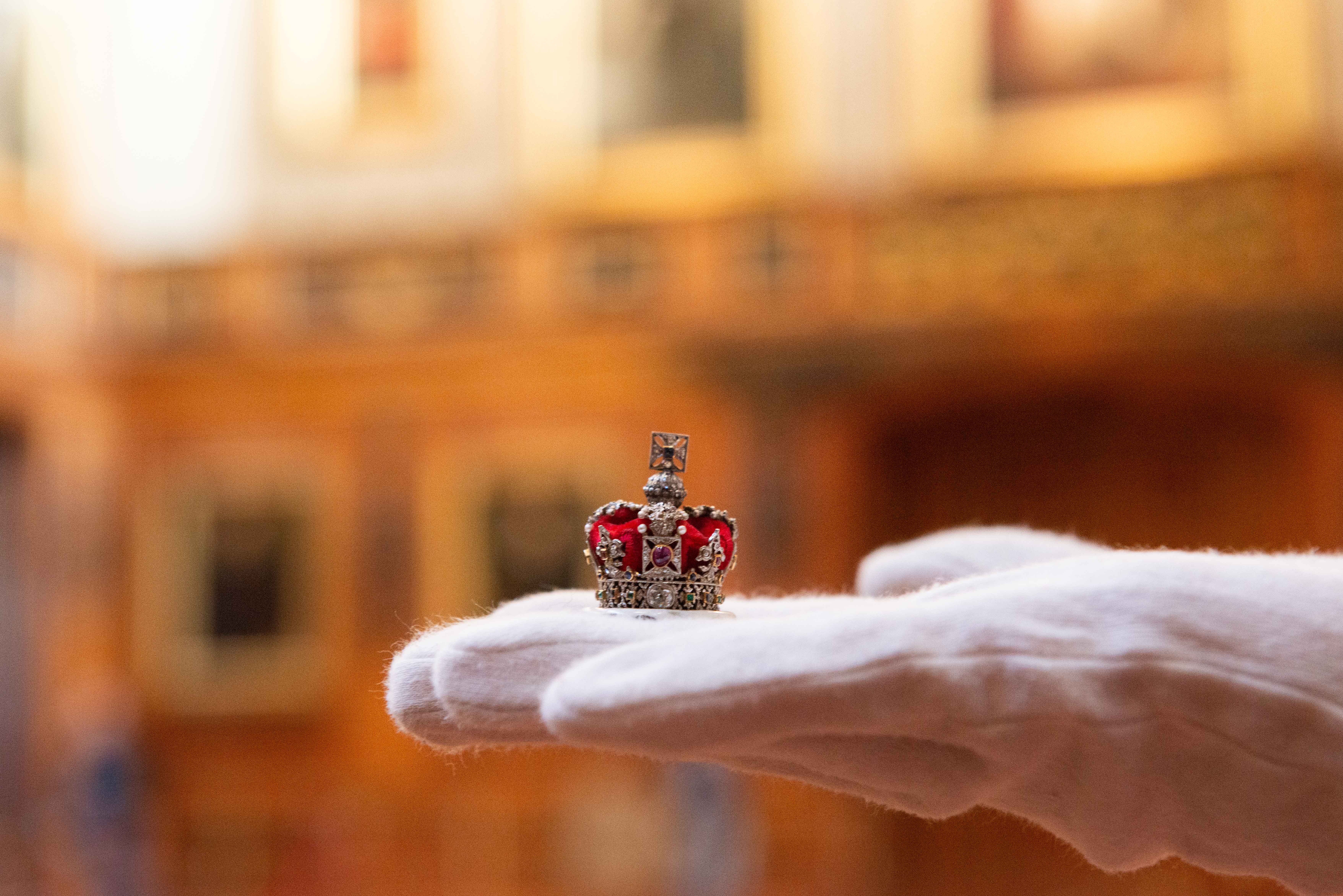 A special display has opened to celebrate the centenary of Queen Mary’s Dolls’ House at Windsor Castle A tiny crown is held by the curator of the special display for the centenary of Queen Mary’s Dolls’ House at Windsor Castle