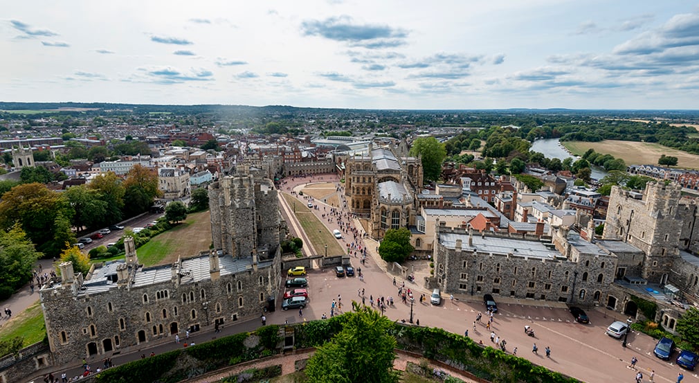 The view from of Windsor from the tower. High up panoramic view of the castle grounds, houses and landscape.