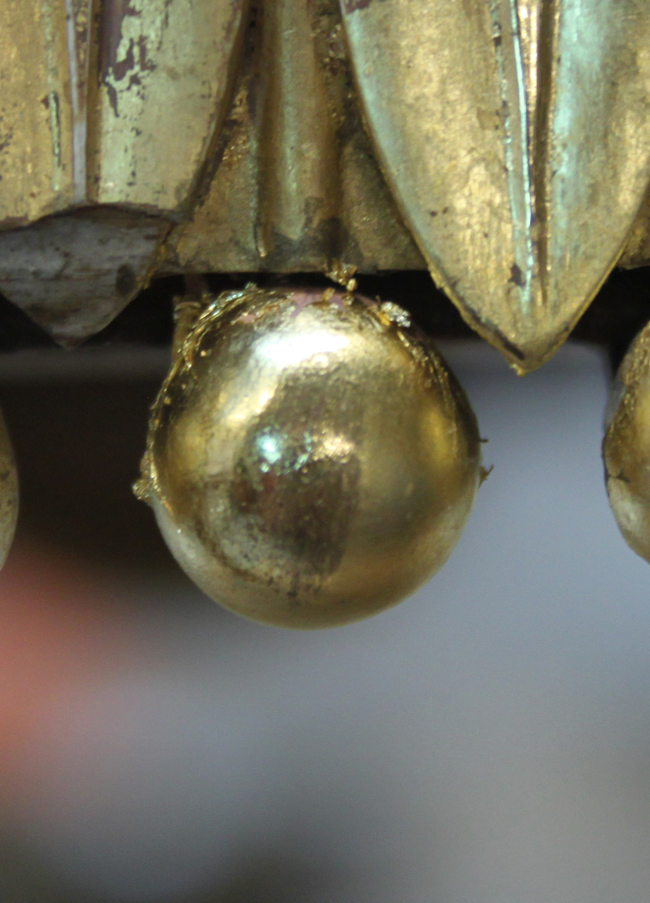 A close-up of one of the balls part-way through burnishing Cropped detail of a ball after burnishing, showing half and half