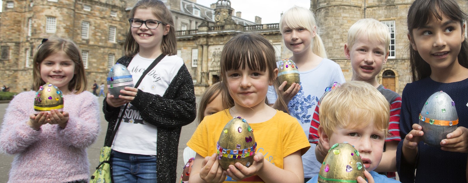 Children holding decorated eggs 