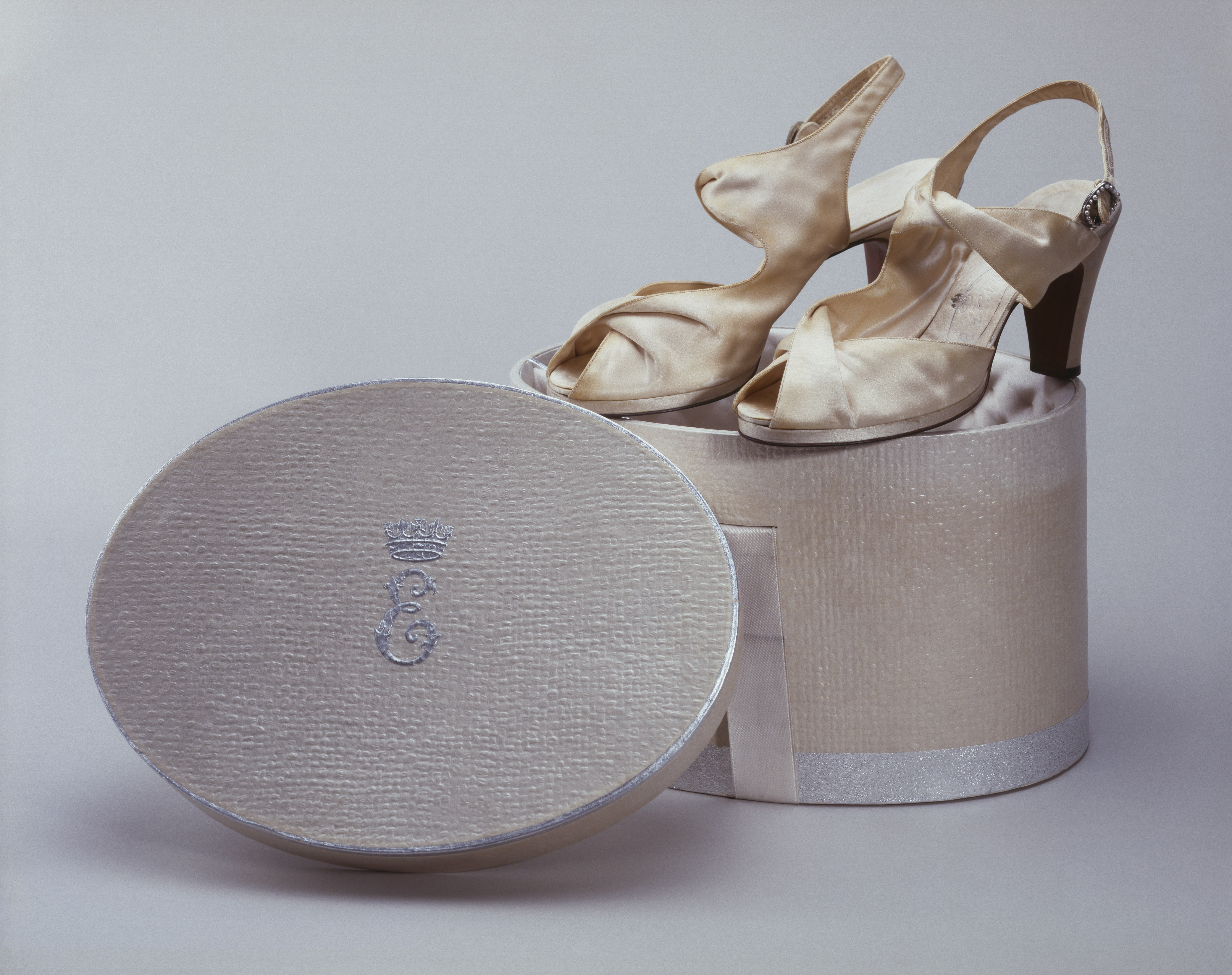 A pair of cream coloured shoes on a shoe box