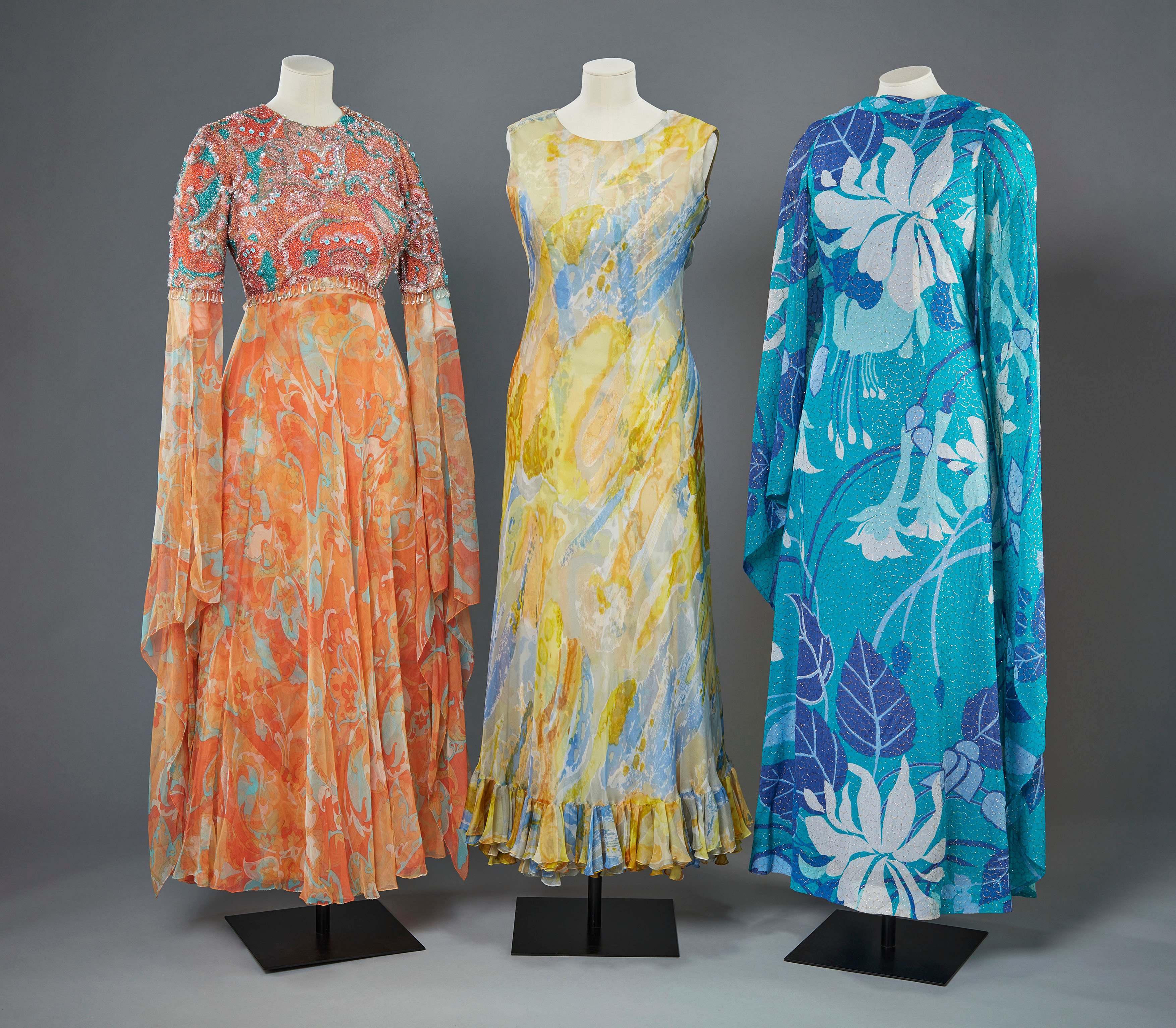 Evening Gowns, Ian Thomas, c. 1970s. Credit: © Royal Collection Enterprises Limited 2025 | Royal Collection Trust. Photographer: Jon Stokes . Three brightly coloured evening gowns.