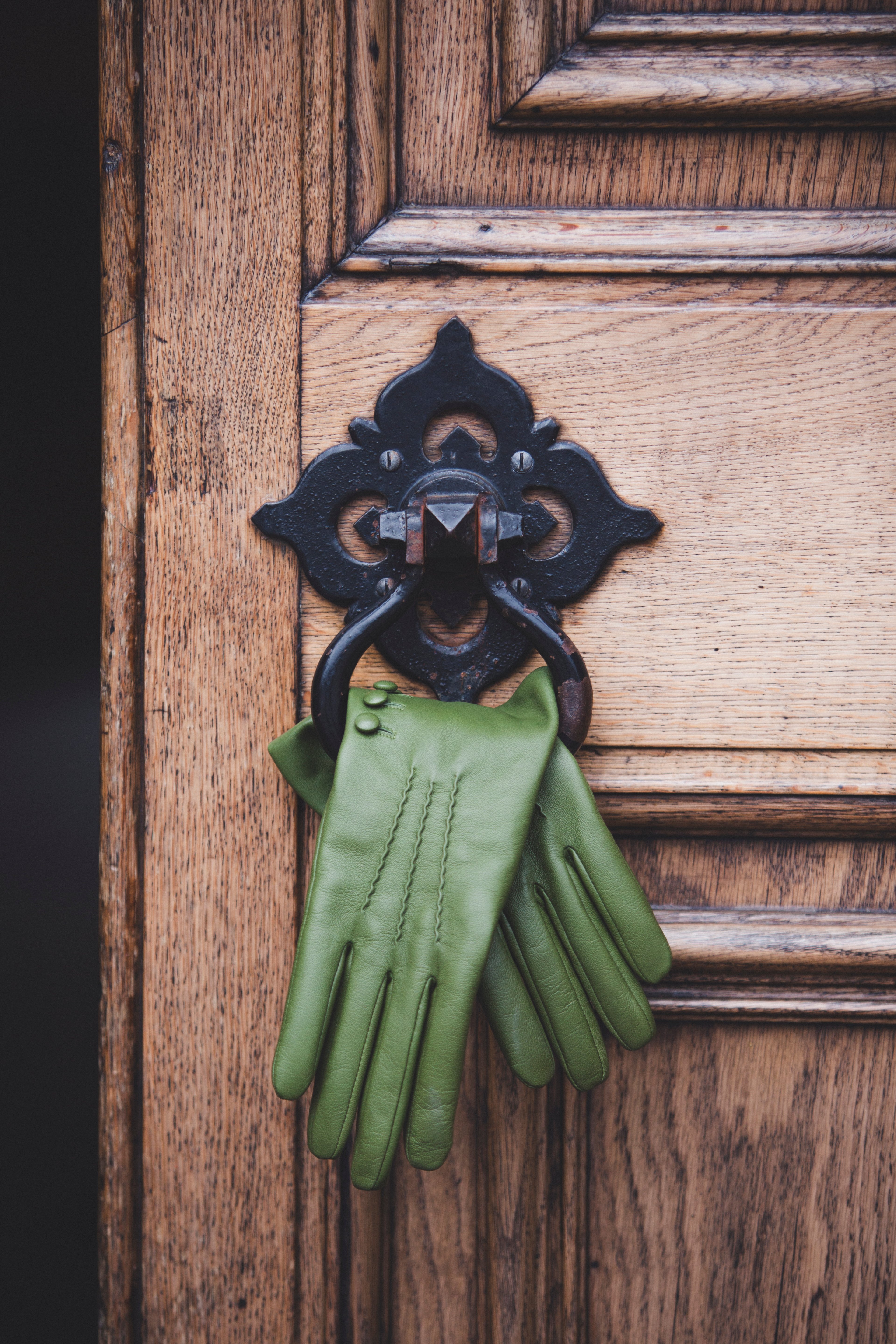 Green leather gloves hand from a door handle