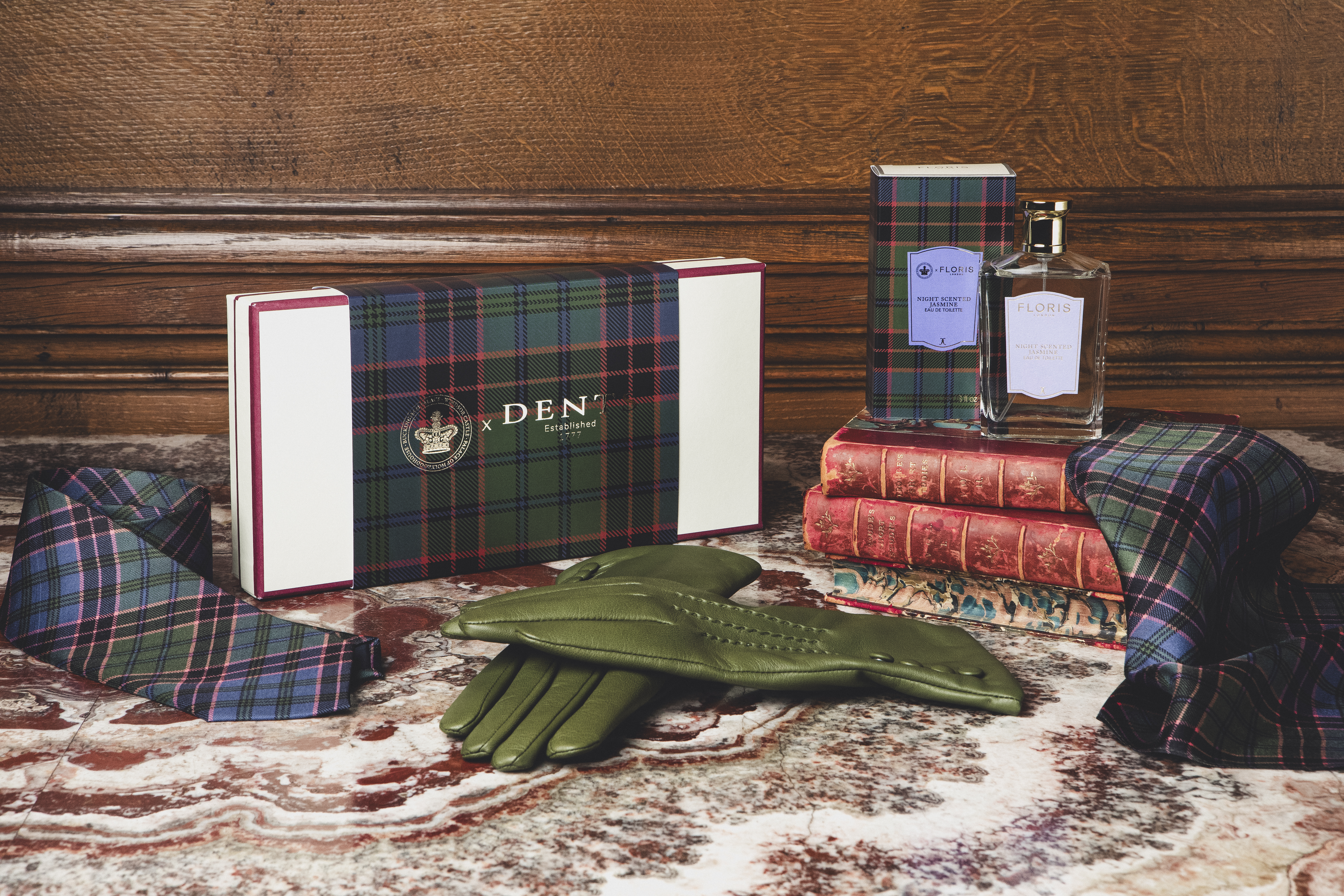 Fine items including leather gloves and perfume assembled on a marble table top