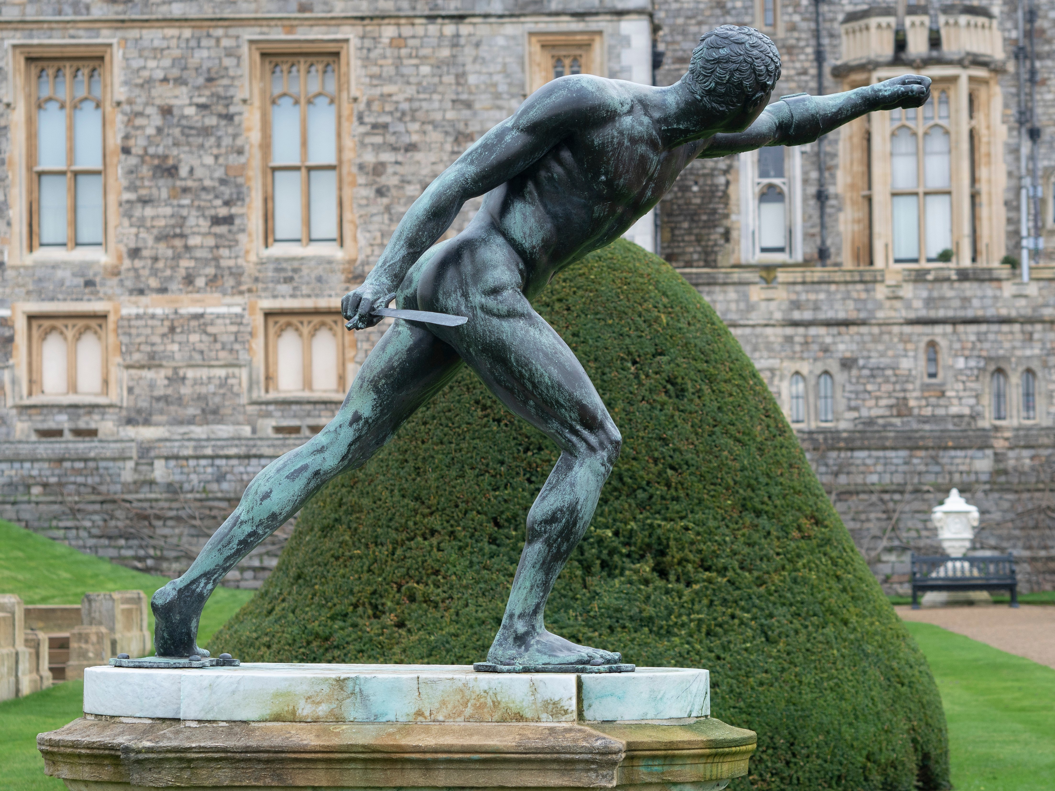 Sculpture of a gladiator by Hubert Le Sueur (RCIN 71436) A sculpture of a man leaning steeply forward with legs wide apart. The sculpture is in a garden.
