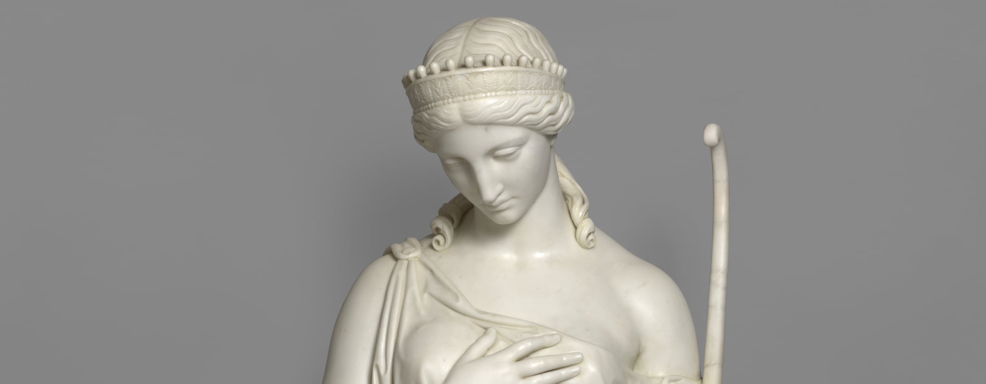 Head and shoulders of a standing figure in classical dress.