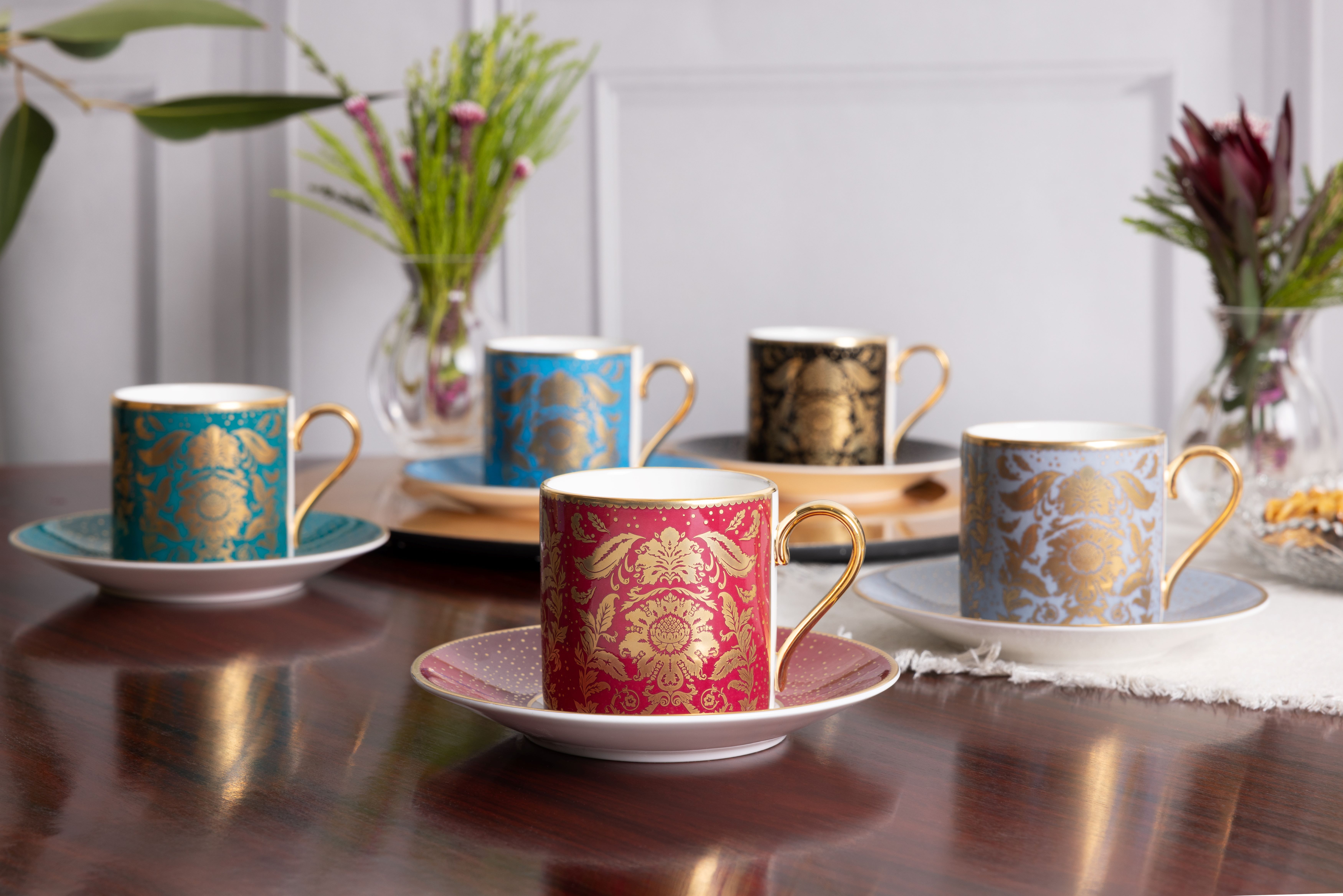 A selection of coffee cups and saucers in pink, black, teal, blue and greywhite