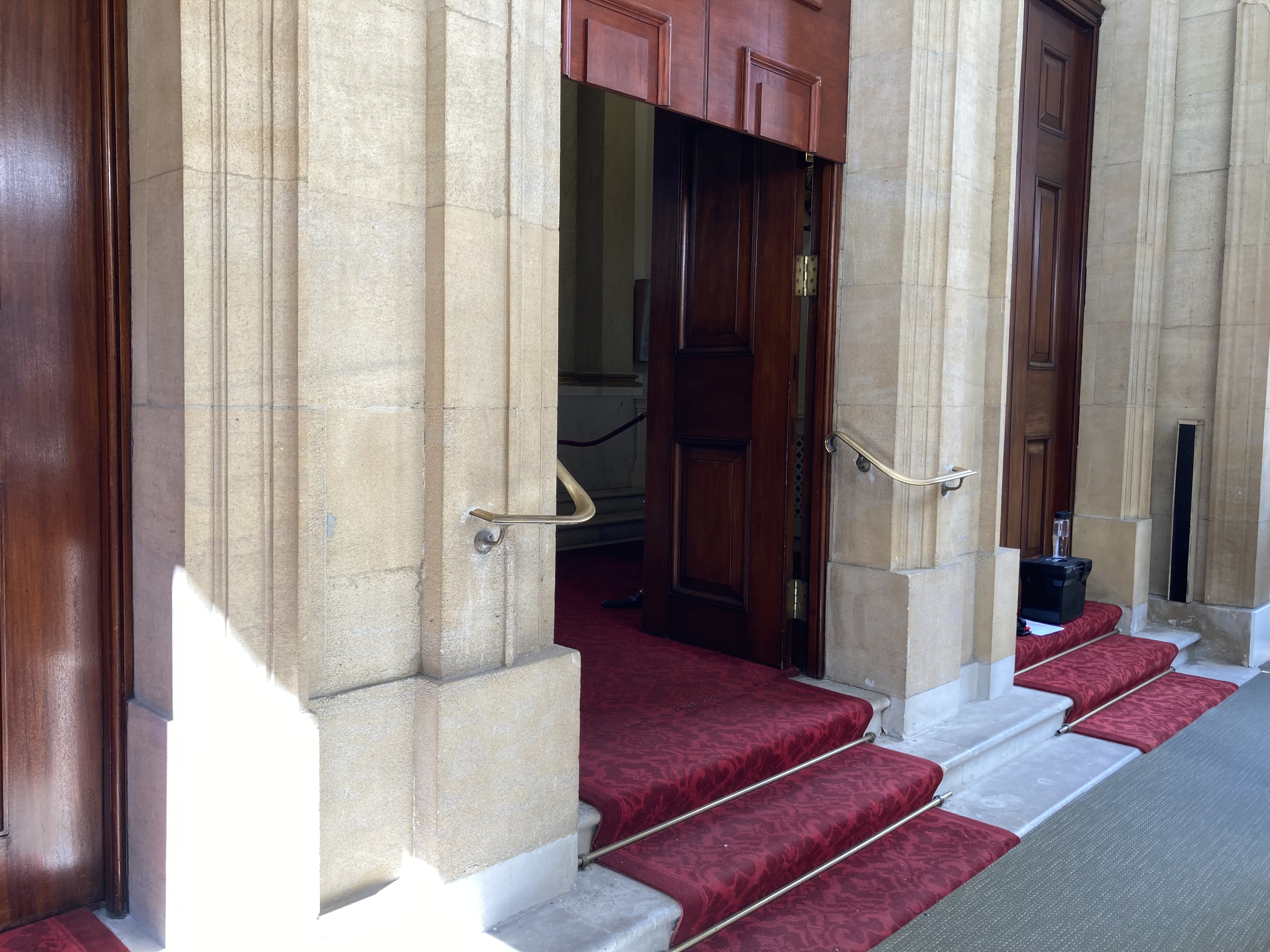 Two red carpeted steps up into the Palace