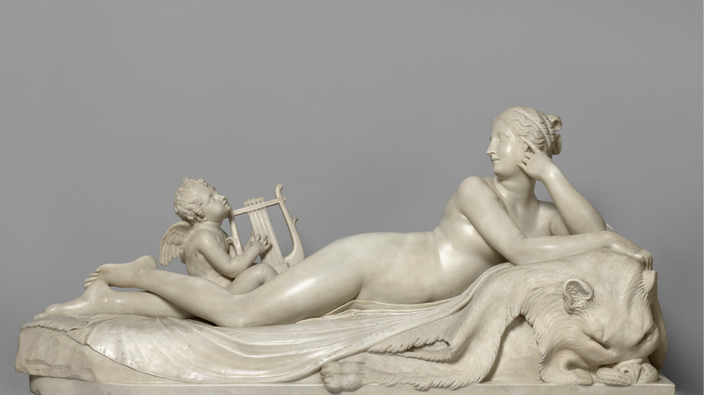 A rectangular statuary marble group carved from two separate blocks for the female figure and the putto.