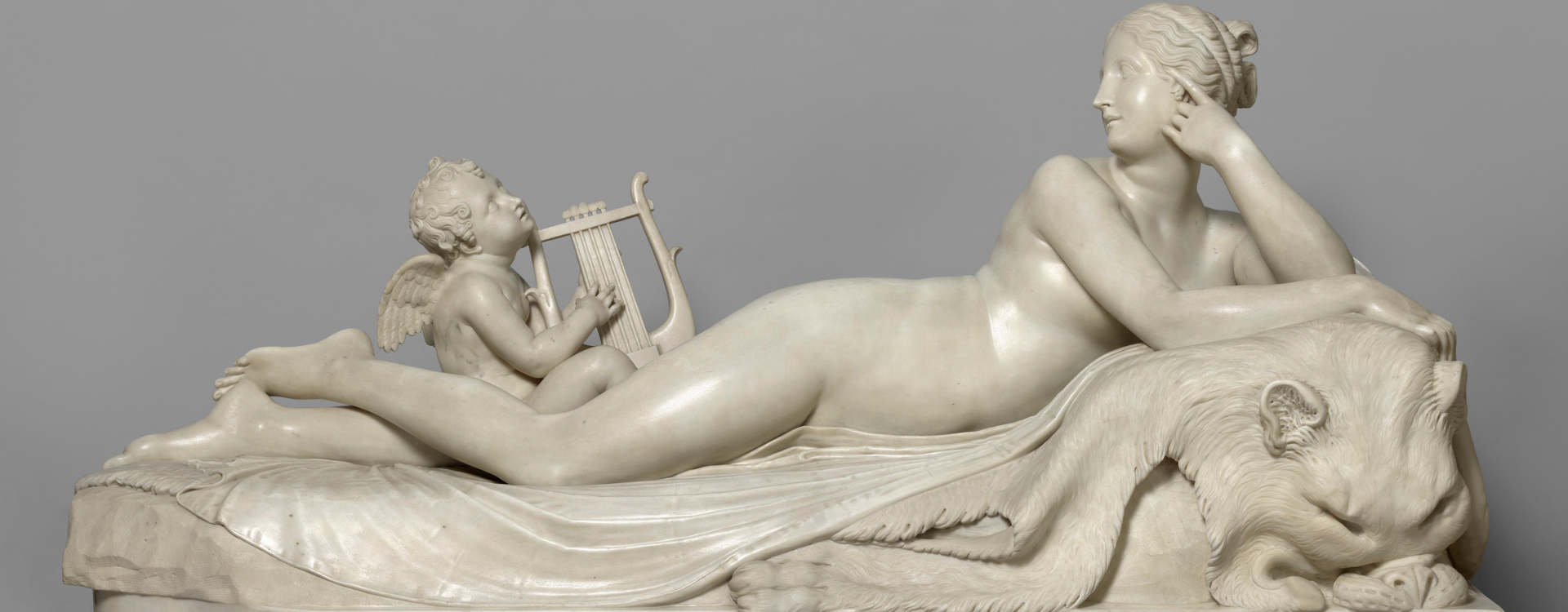 A rectangular statuary marble group carved from two separate blocks for the female figure and the putto.