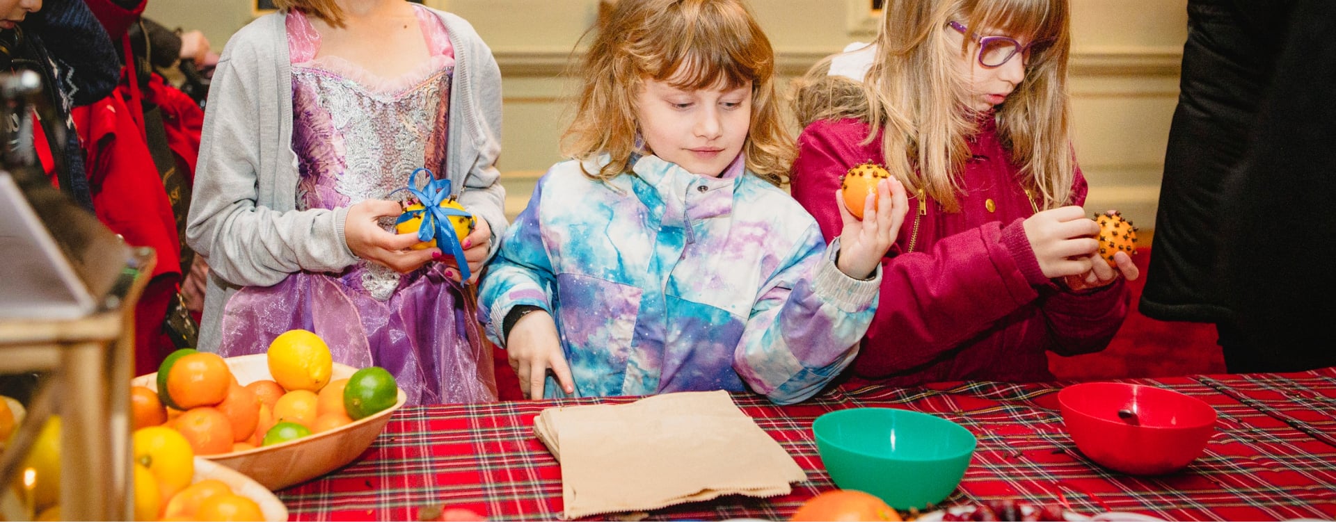 3 children taking part in a craft activity with oranges