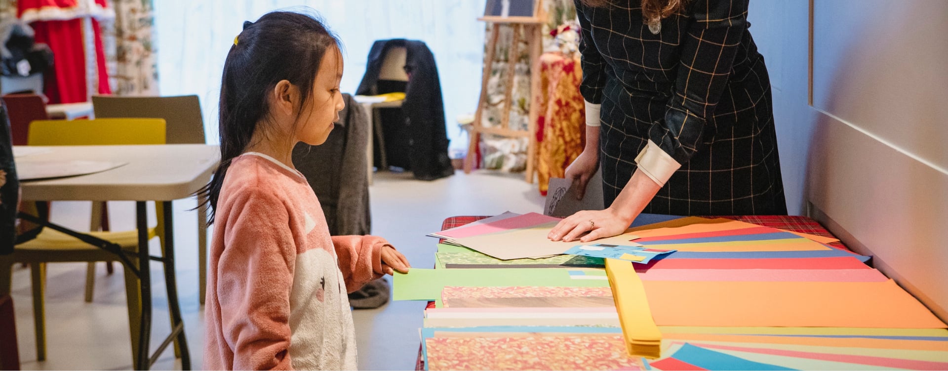 An Edwardian Christmas: Family Workshop A child looks at craft materials on a table.