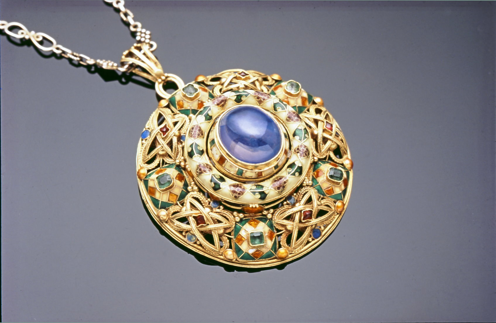 Gold, sapphire cabochon and polychrome enamel pendant made by Murphy at The Falcon Studio Gold, sapphire cabochon and polychrome enamel pendant made by Murphy at The Falcon Studio