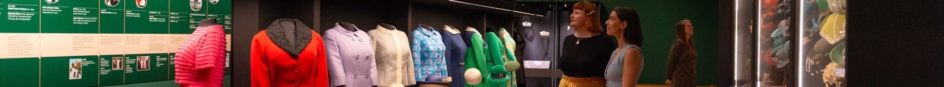 Rows of colourful outfits in the exhibition Queen Elizabeth II: Her Life in Style