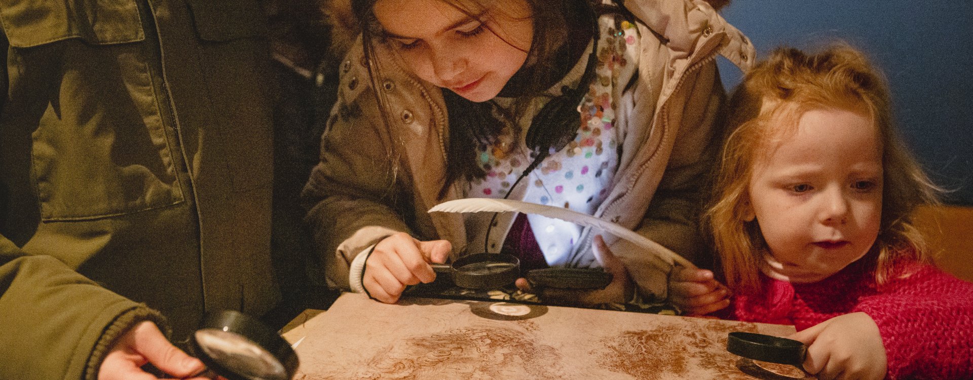 child explores drawing with magnifying glass