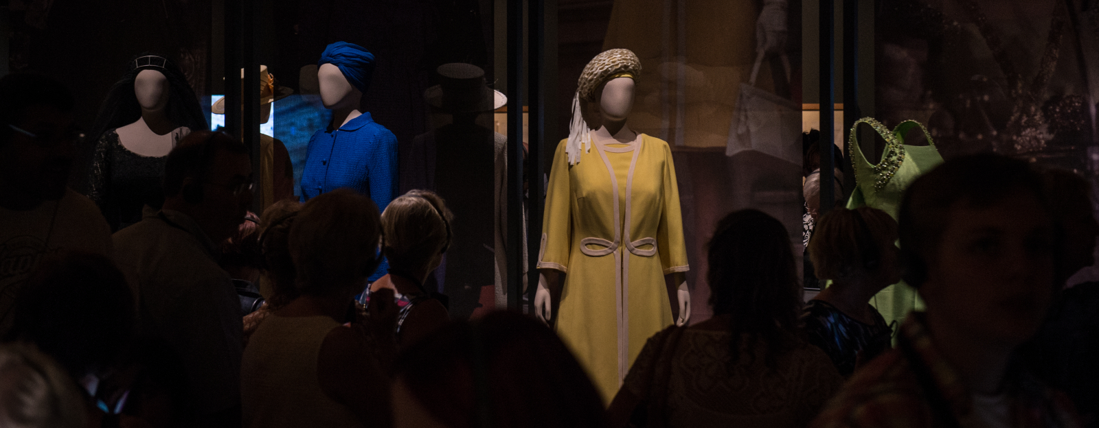 blue and yellow outfits on display in a darkened room
