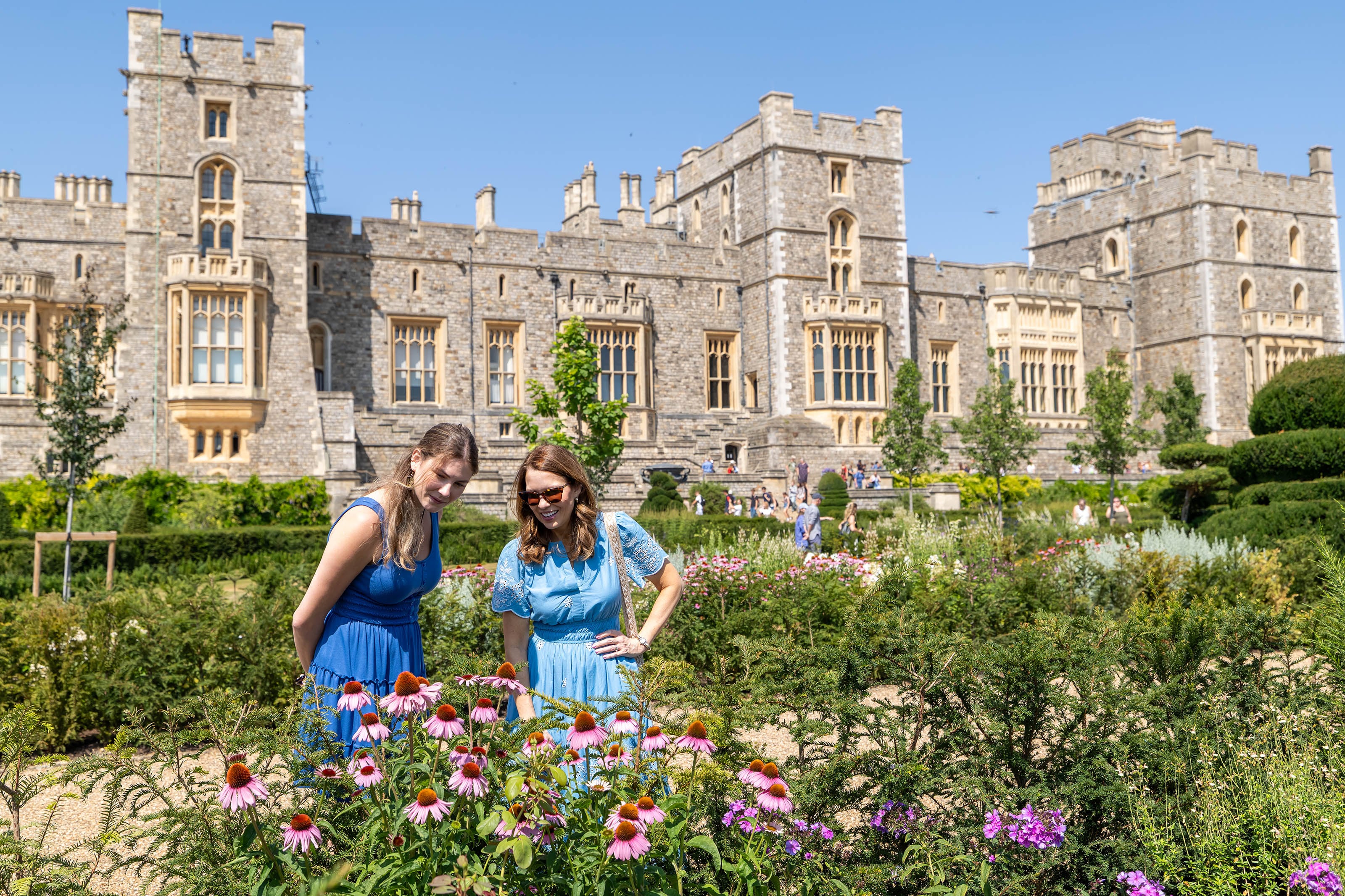 Two visitors looking at flowers in the Venus Garden, with Windsor Castle in the background