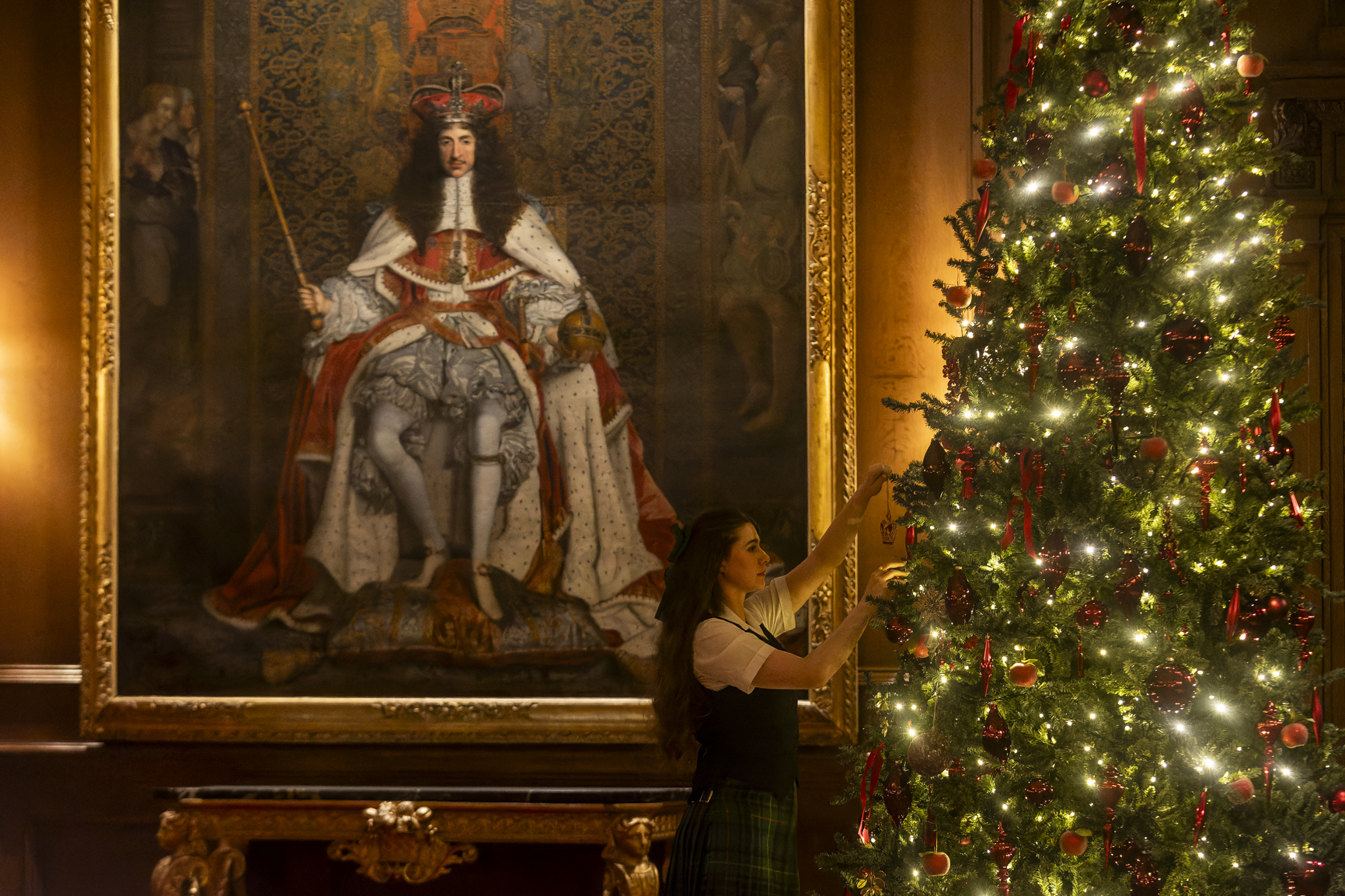 A staff member making final adjustments to the Christmas tree in the Throne Room