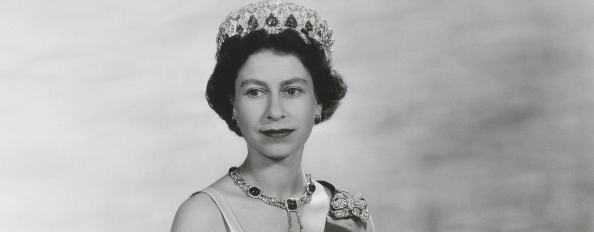 Portrait of Queen Elizabeth II by Baron, released to mark the Queen’s State Visit to France in April 1957. Black and white portrait of Queen Elizabeth II by Baron. The Queen is wearing a cream silk evening gown designed by Sir Norman Hartnell.