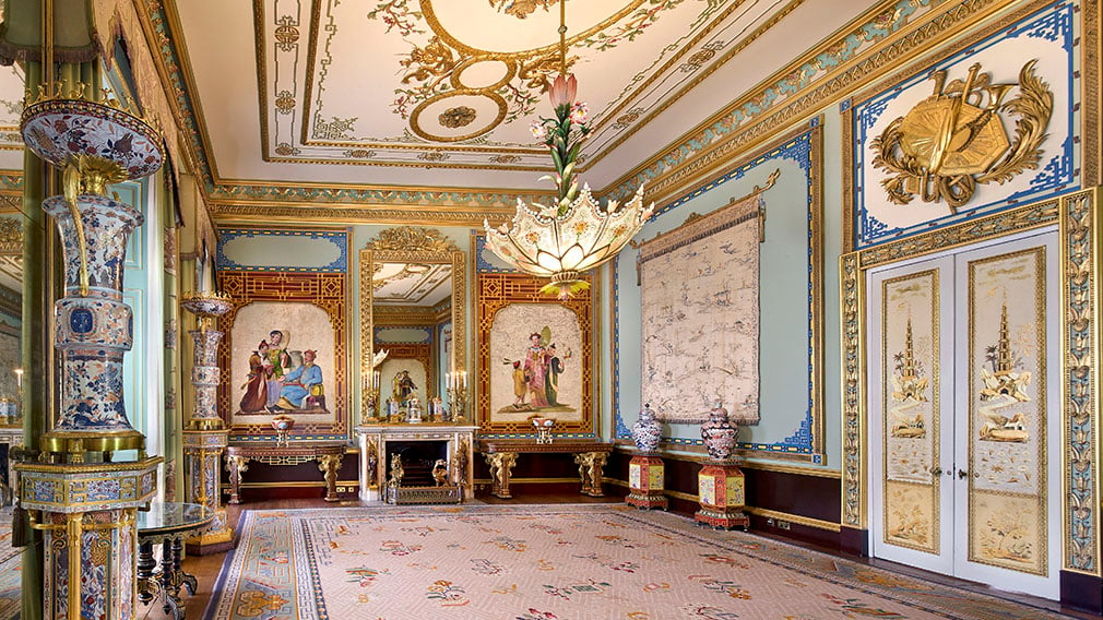 A ornately decorated room with a lotus shaped chandelier and porcelain vases.