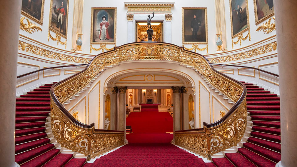 Grand Staircase A double staircase with red carpet and gold banisters. The walls are lined with paintings.