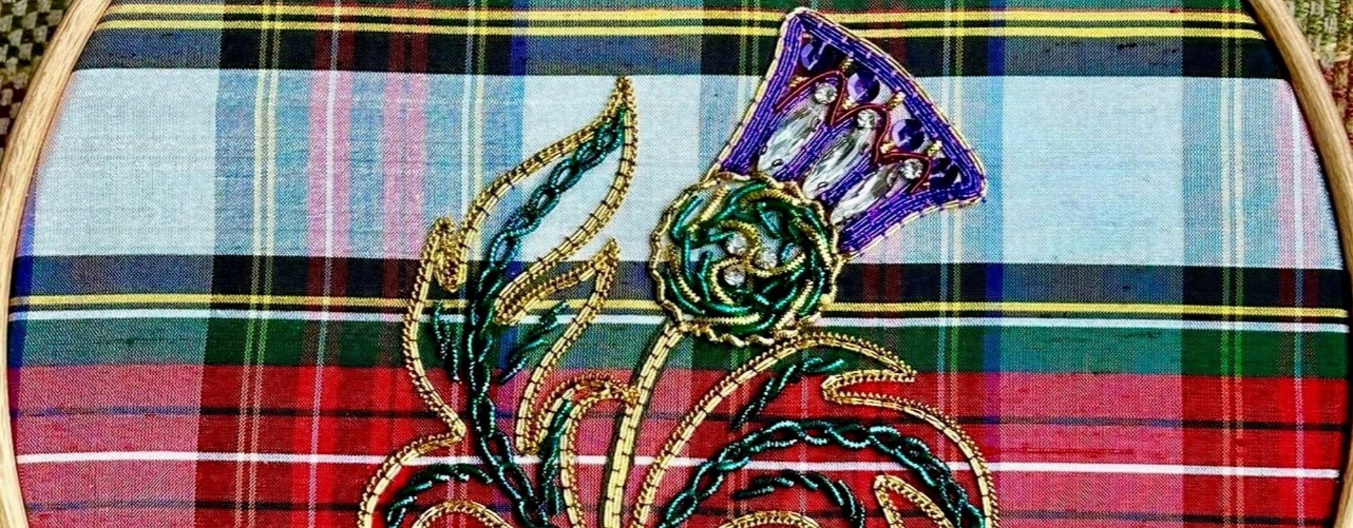 An embroidered thistle on a tartan background