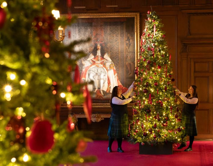 Christmas at the Palace of Holyroodhouse Photographer: Jane Massey Two people in kilts decorating a Christmas tree