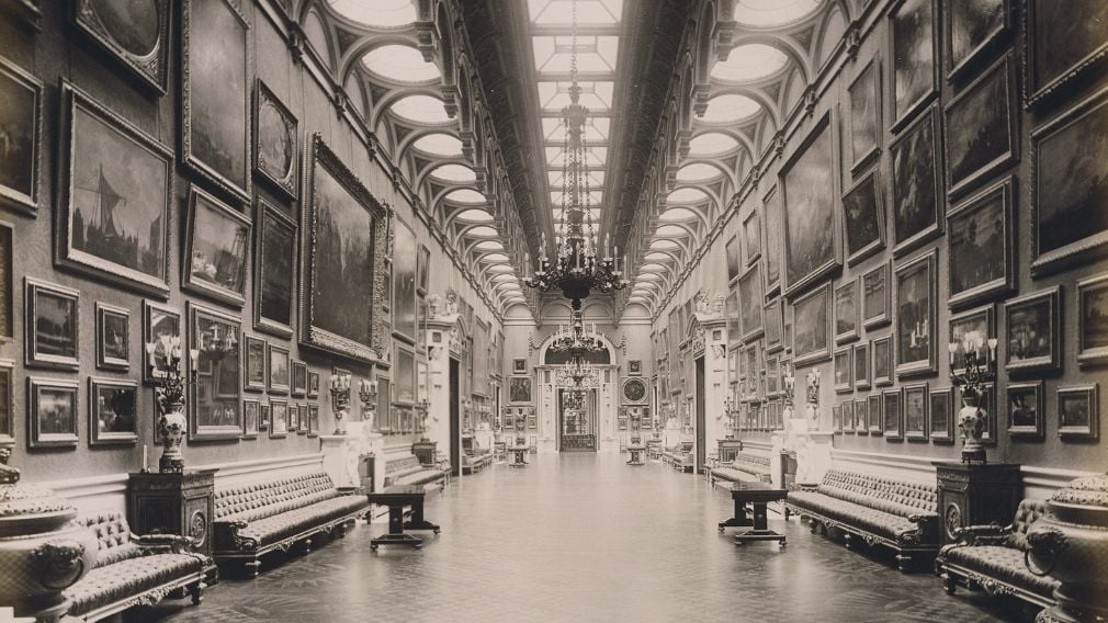 W & D Downey, The Picture Gallery at Buckingham Palace (looking North), 1910 (RCIN 2104521) Black and white photograph of a long room with paintings on the wall.