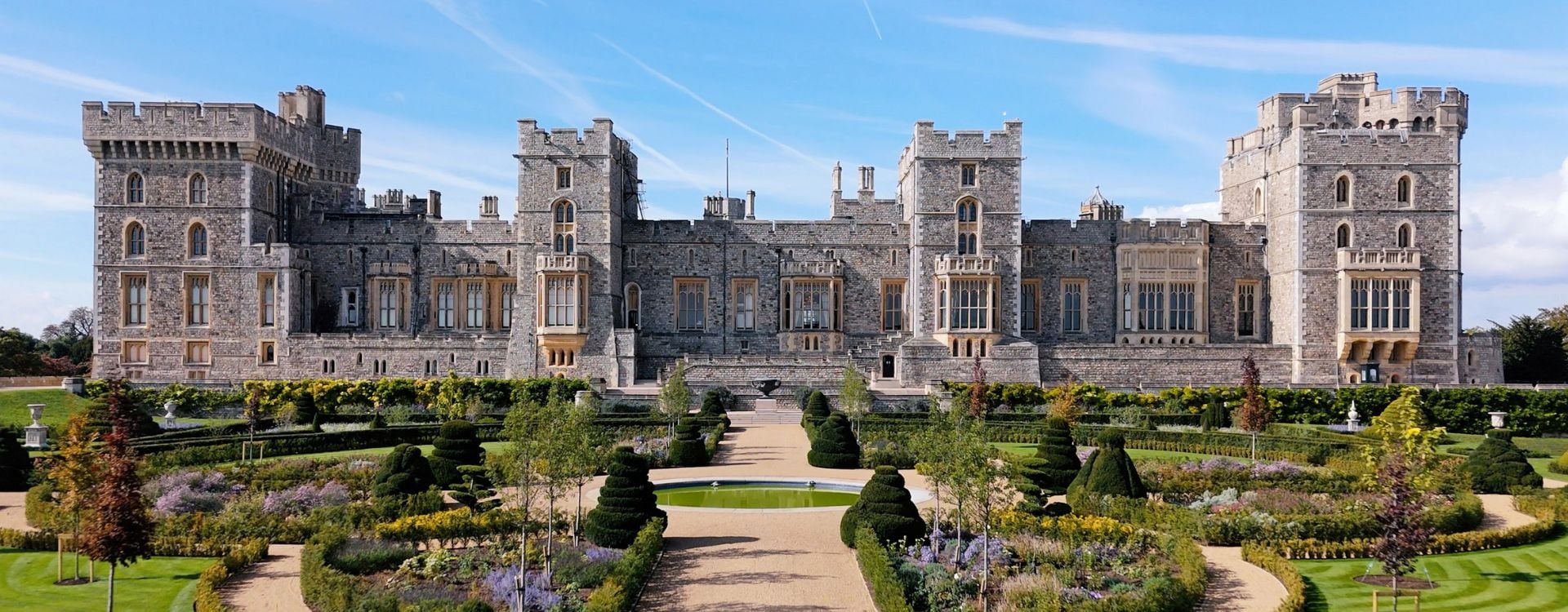 A garden with a castle in the background.