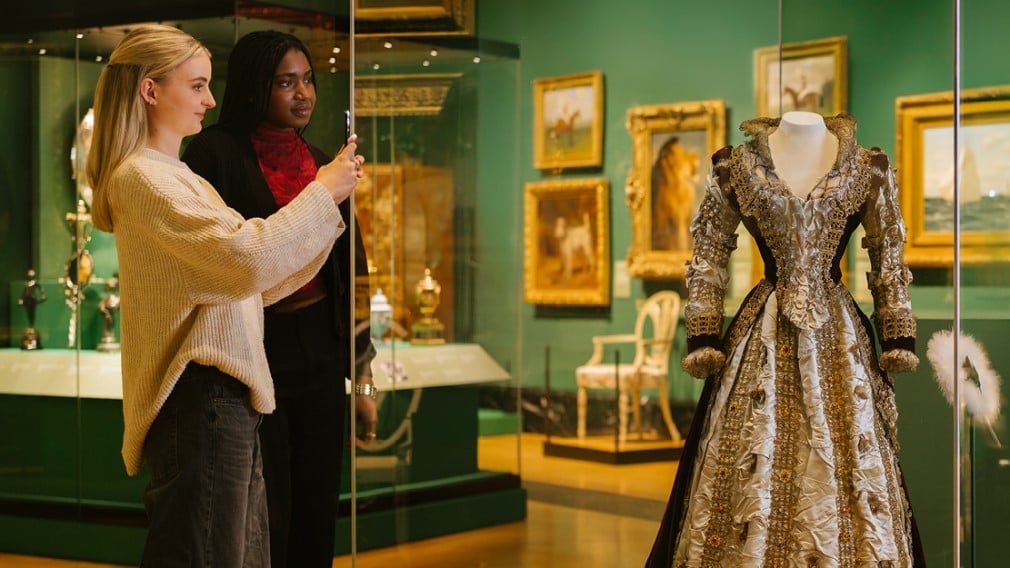 Inside the exhibition 'The Edwardians: Age of Elegance' Visitors taking a picture of a dress in the exhibition 'The Edwardians: Age of Elegance'